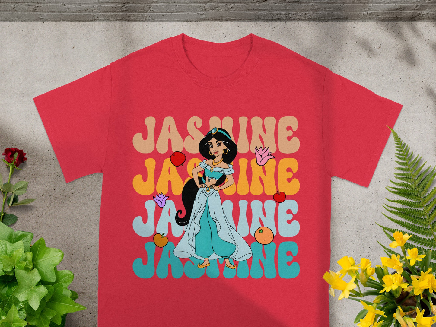 Red t-shirt with "JASMINE" in colorful retro font and character graphic.