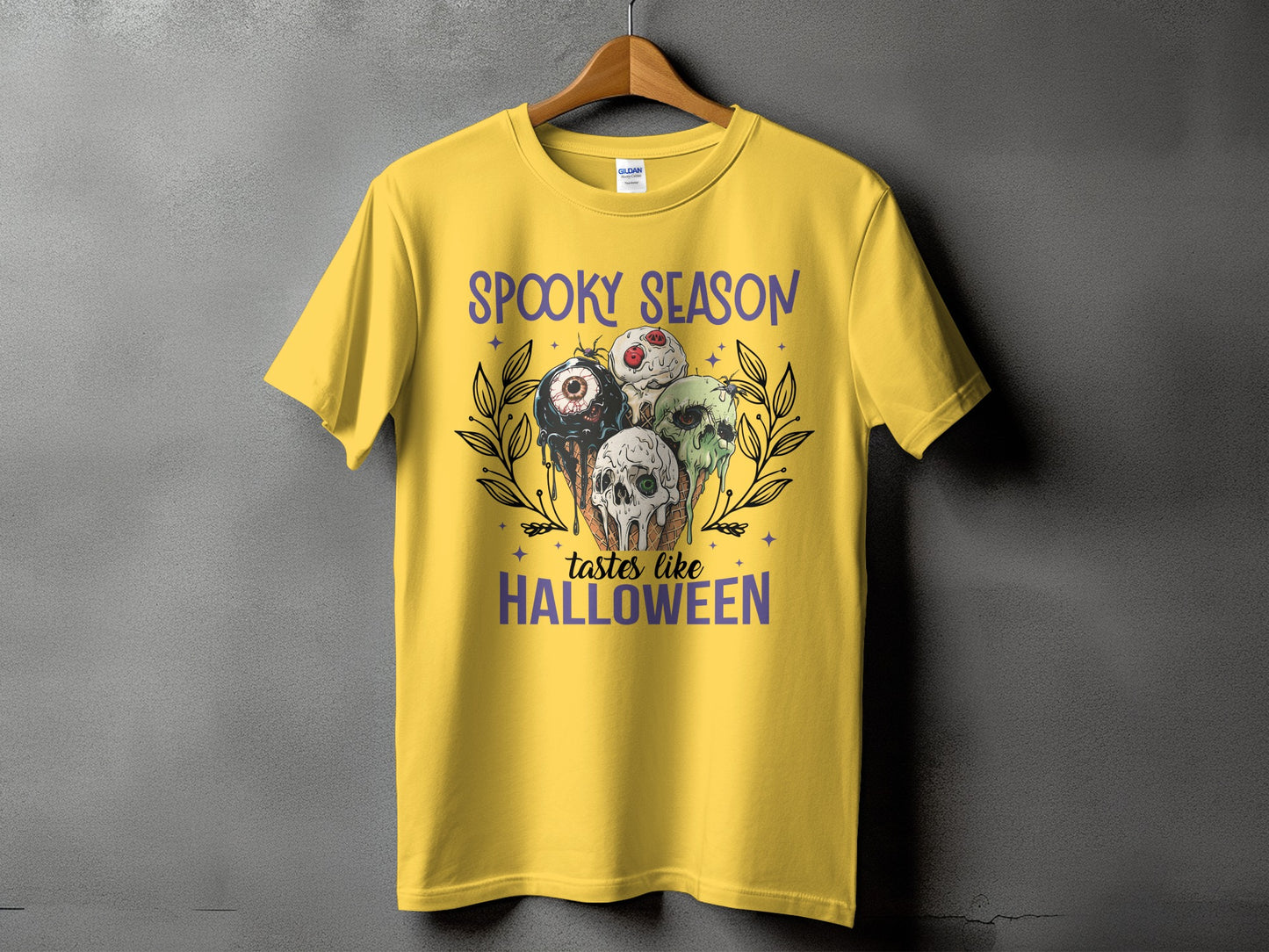 Yellow t-shirt with "Spooky season tastes like Halloween" and Halloween-themed ice cream cones.