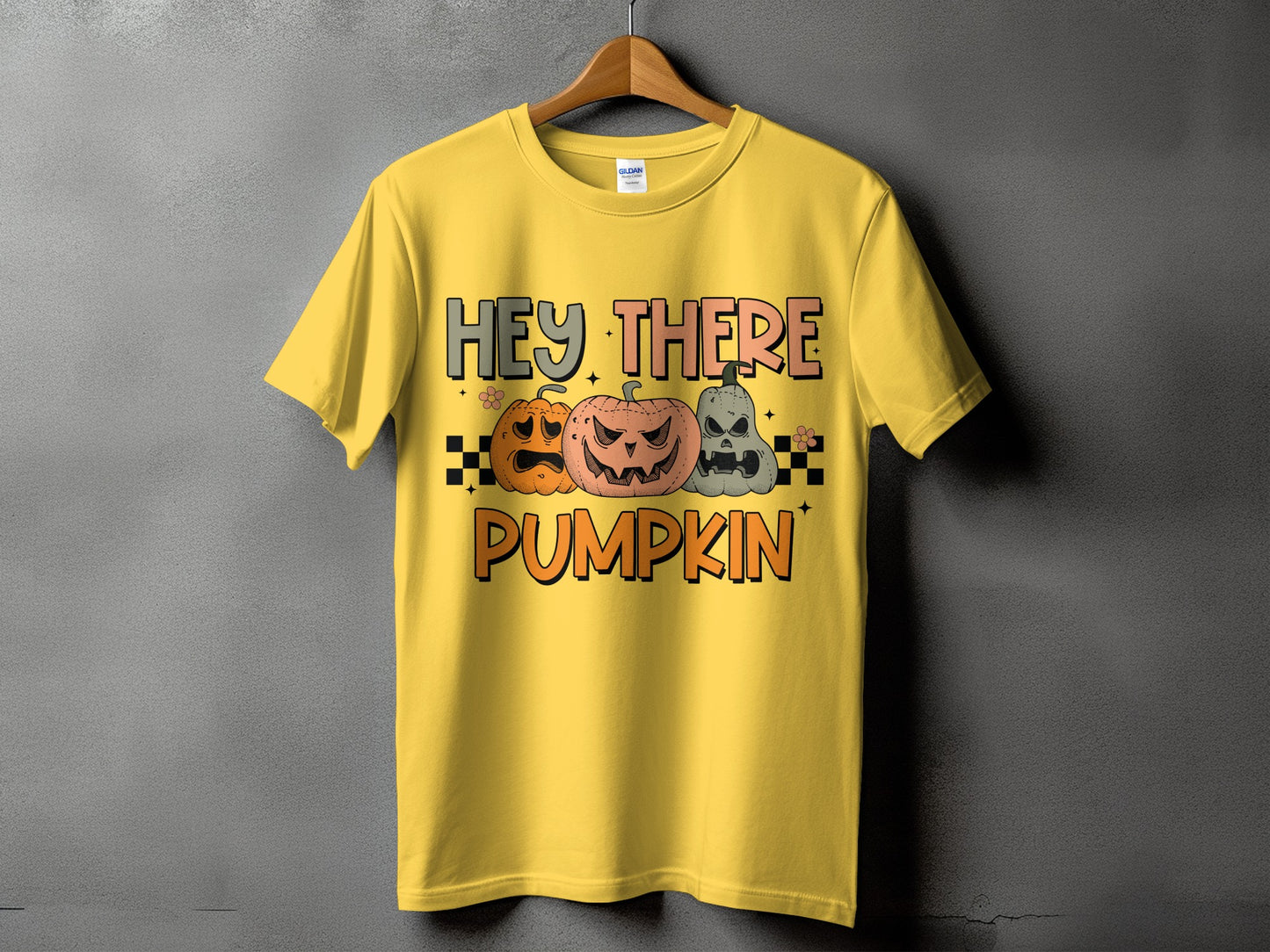Yellow t-shirt with "Hey There Pumpkin" and three carved pumpkins.