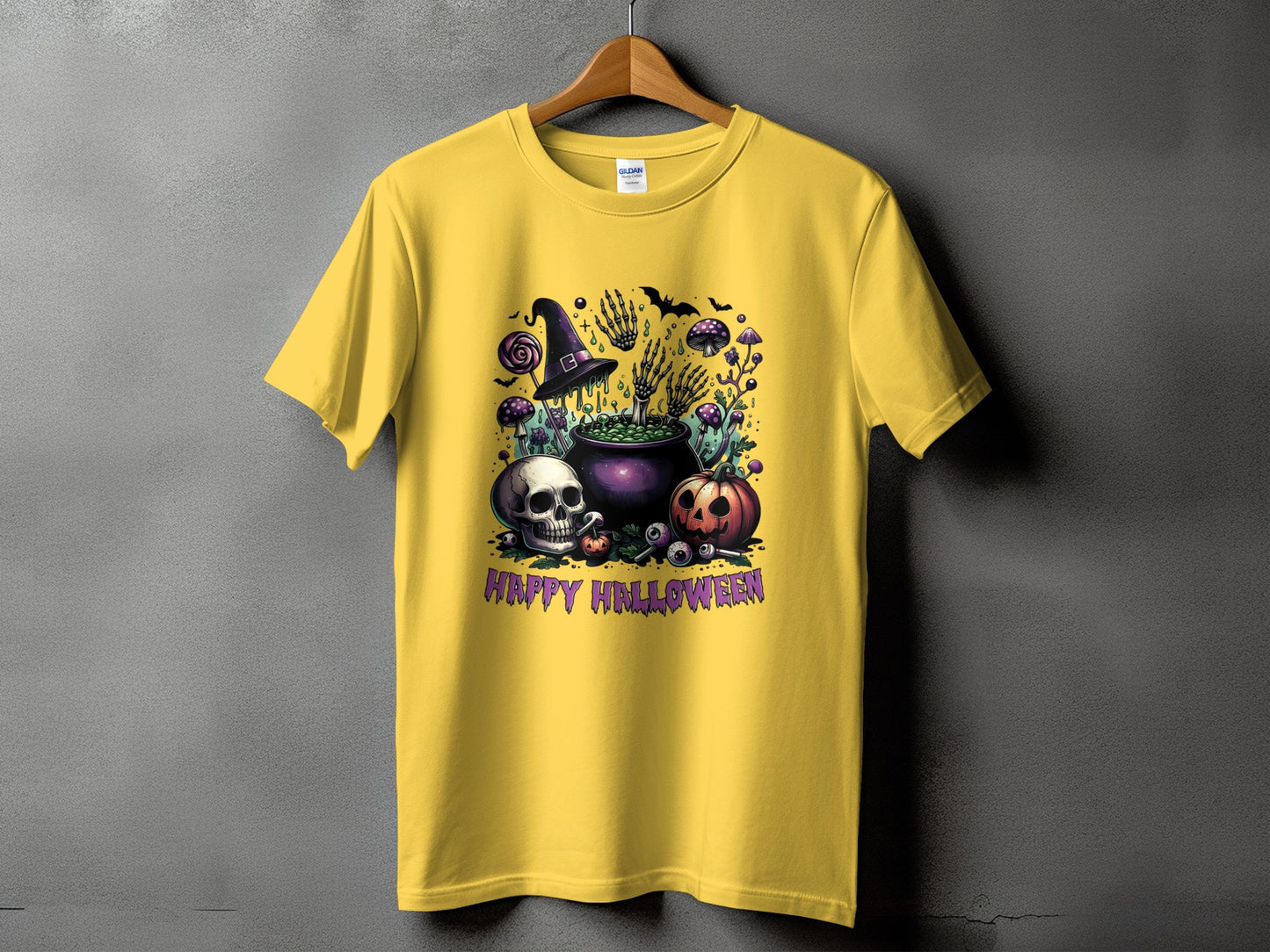 Yellow t-shirt with a Halloween graphic featuring a cauldron, skull, pumpkin, and text.