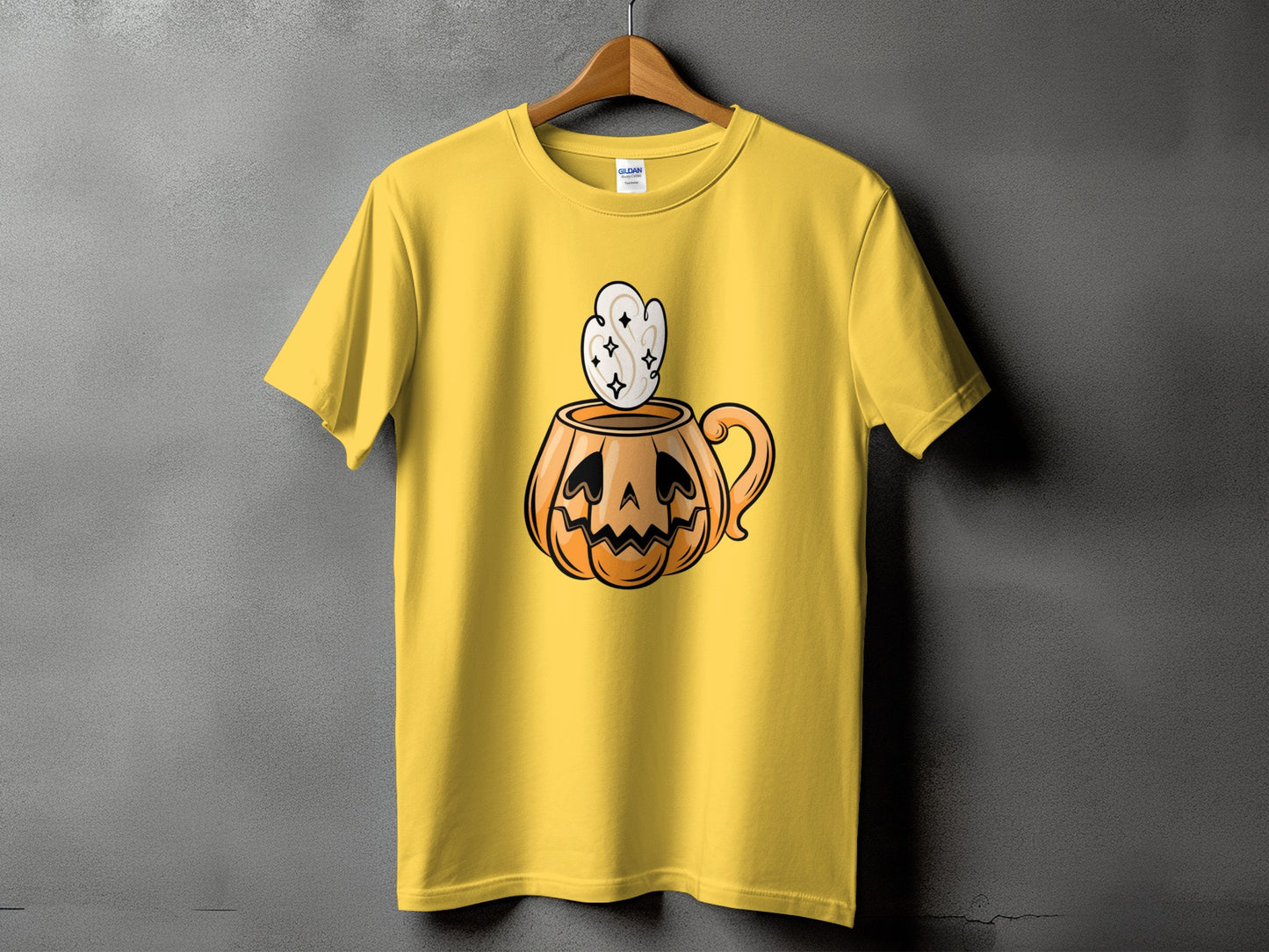 Yellow t-shirt with a cartoon pumpkin mug with steam and stars graphic.