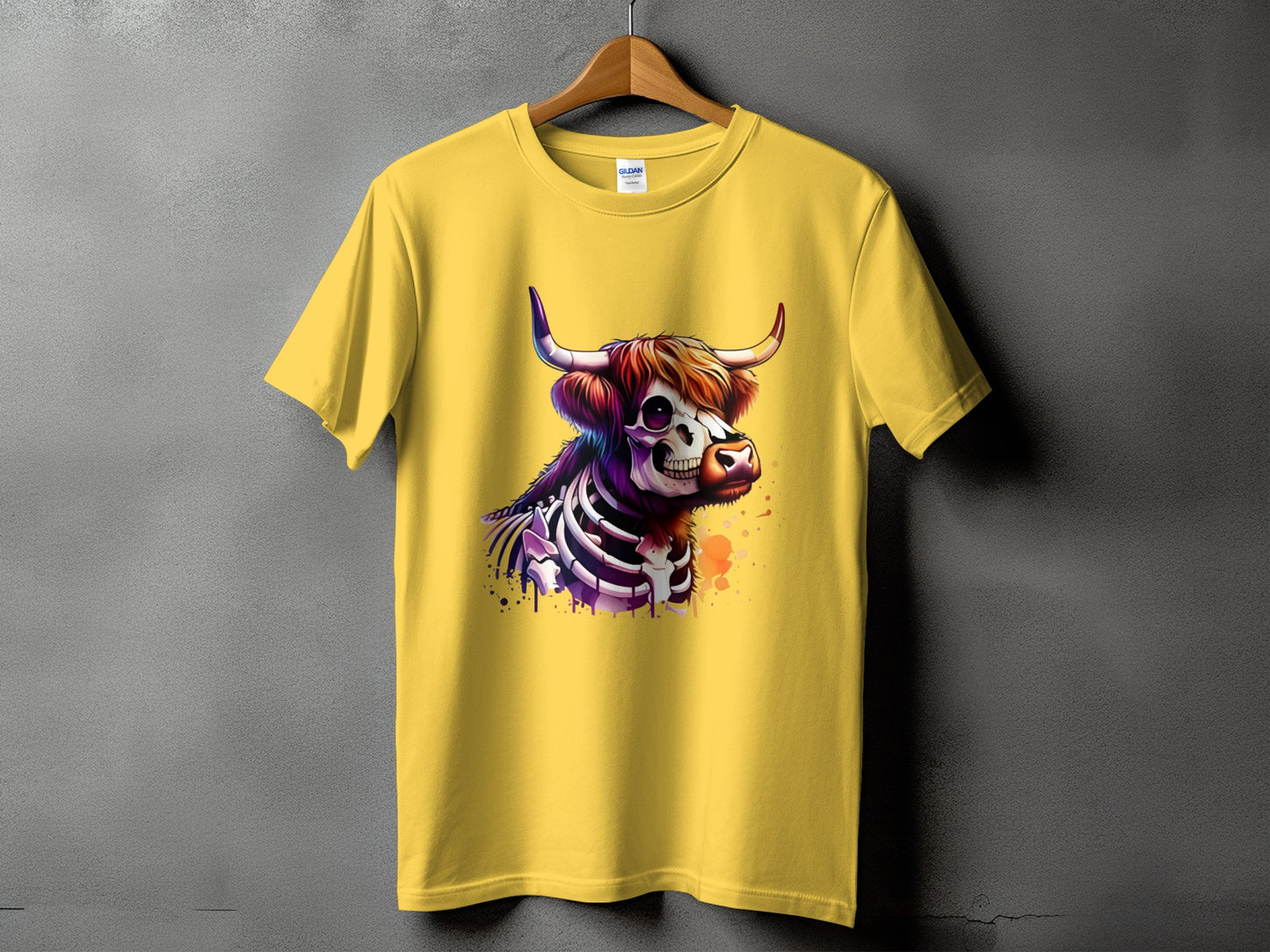 Yellow t-shirt with a skeleton highland cow graphic and splattered paint design.