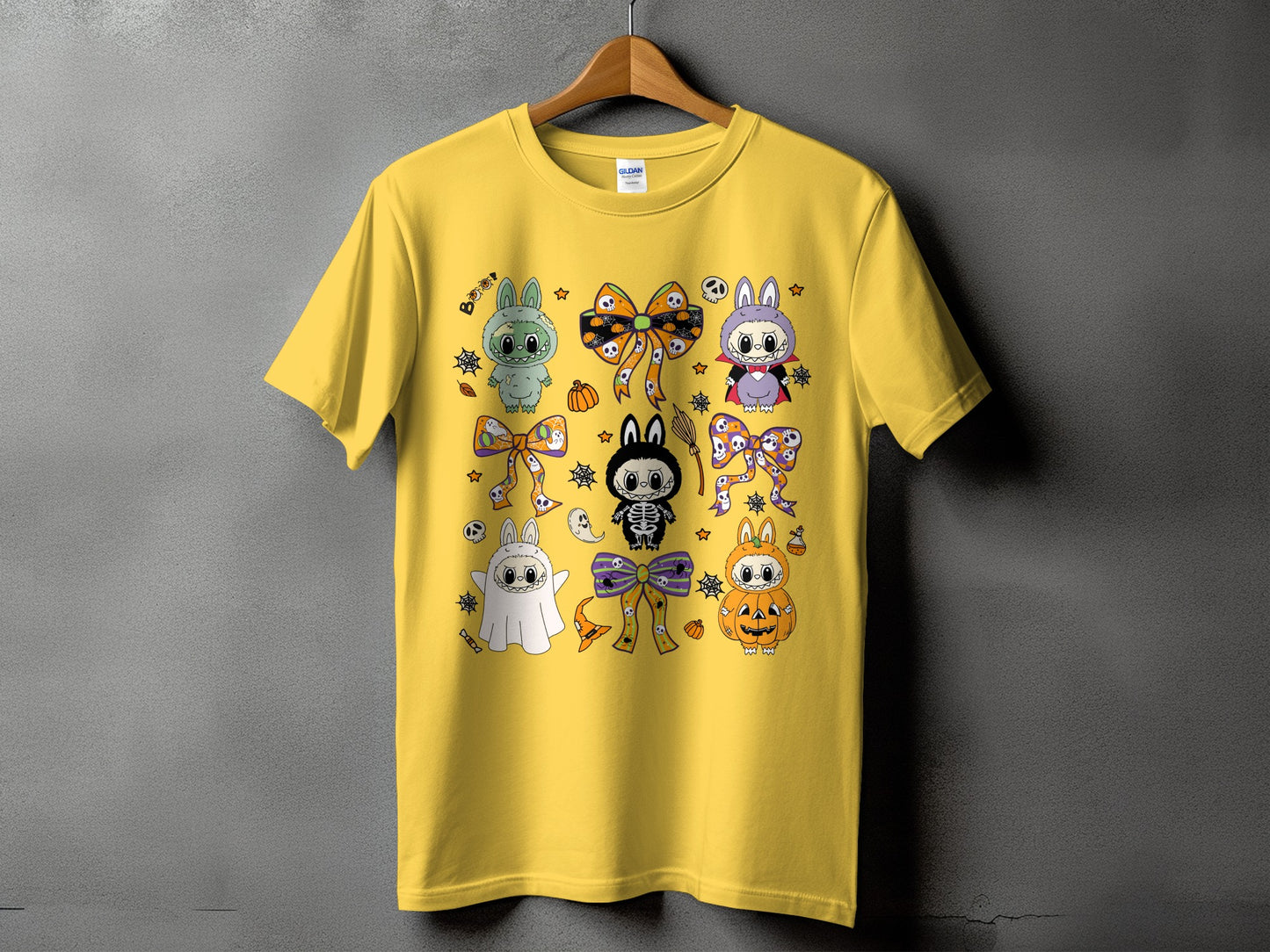 Yellow t-shirt with a collage of cute Halloween characters and bows.
