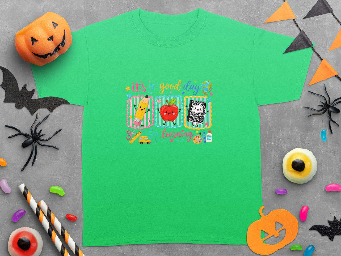 Green t-shirt with "it's a good day for learning" and school icons.