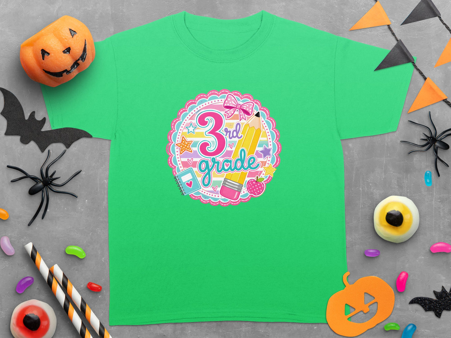 Green t-shirt with "3rd grade" text and school supplies illustration.