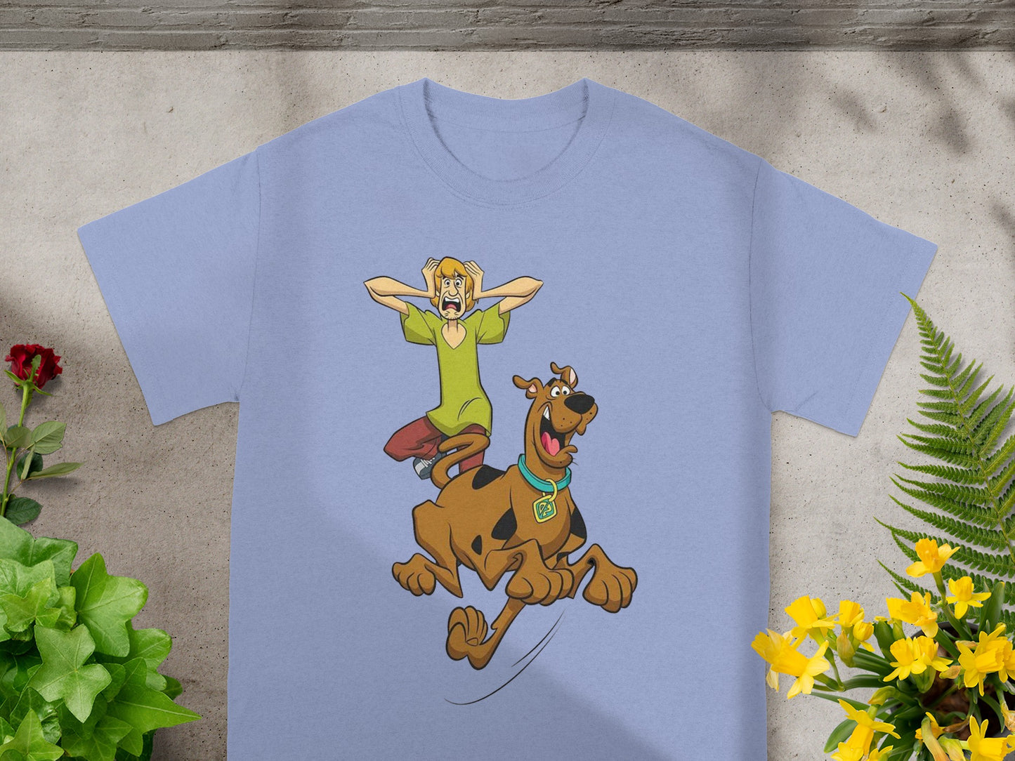 Scooby-Doo and Shaggy running from something, printed on a light blue t-shirt.