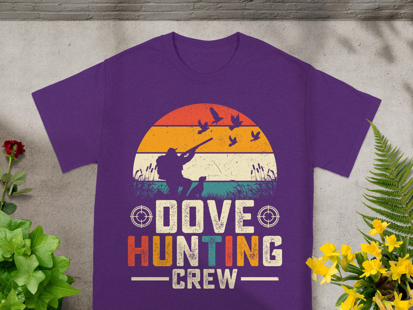 Purple t-shirt graphic with hunter, dog, birds, and "Dove Hunting Crew" text.