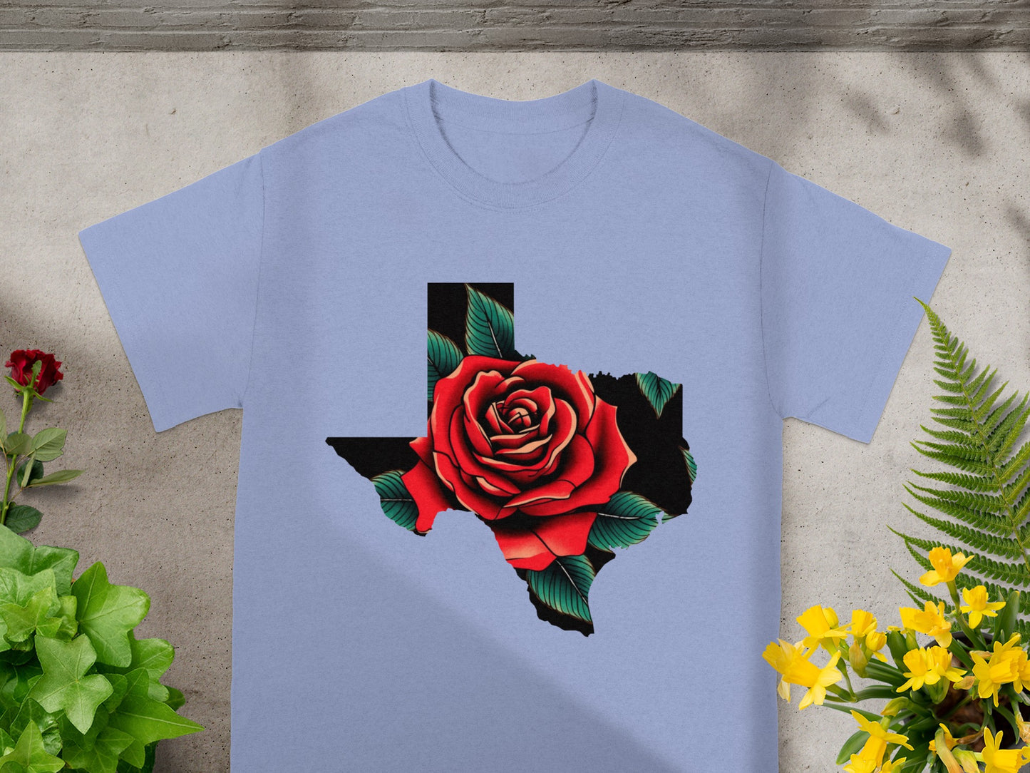 Light blue t-shirt with a graphic of a red rose within the outline of Texas.