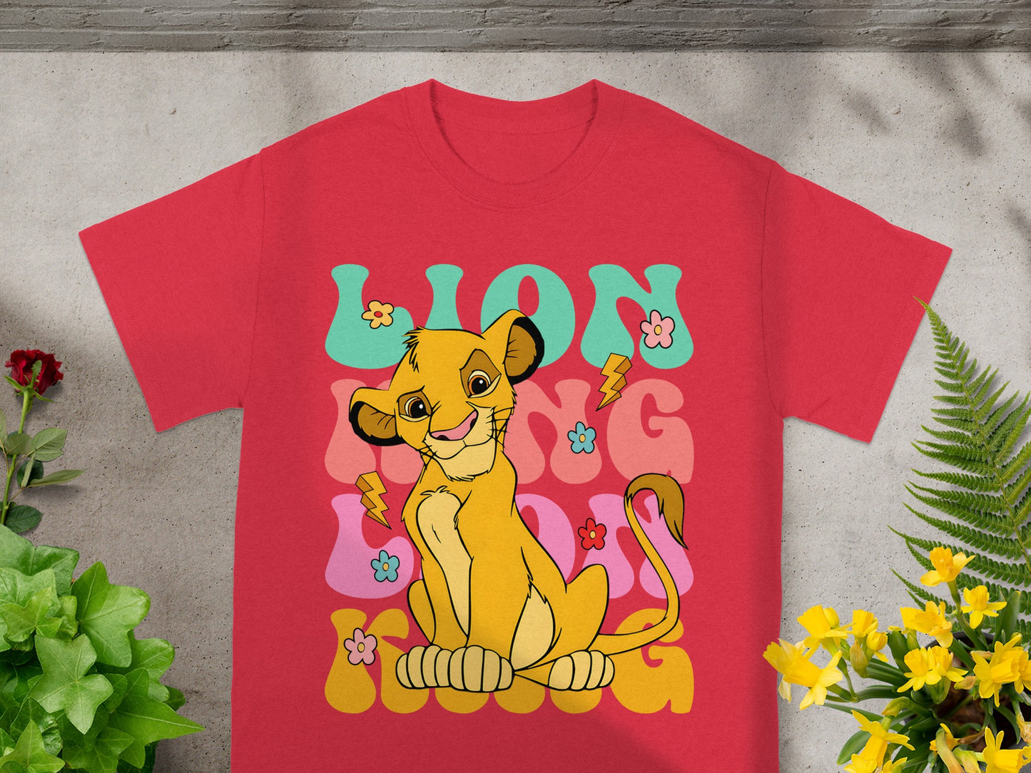 Red t-shirt with Simba and "LION KING" text in a groovy font.