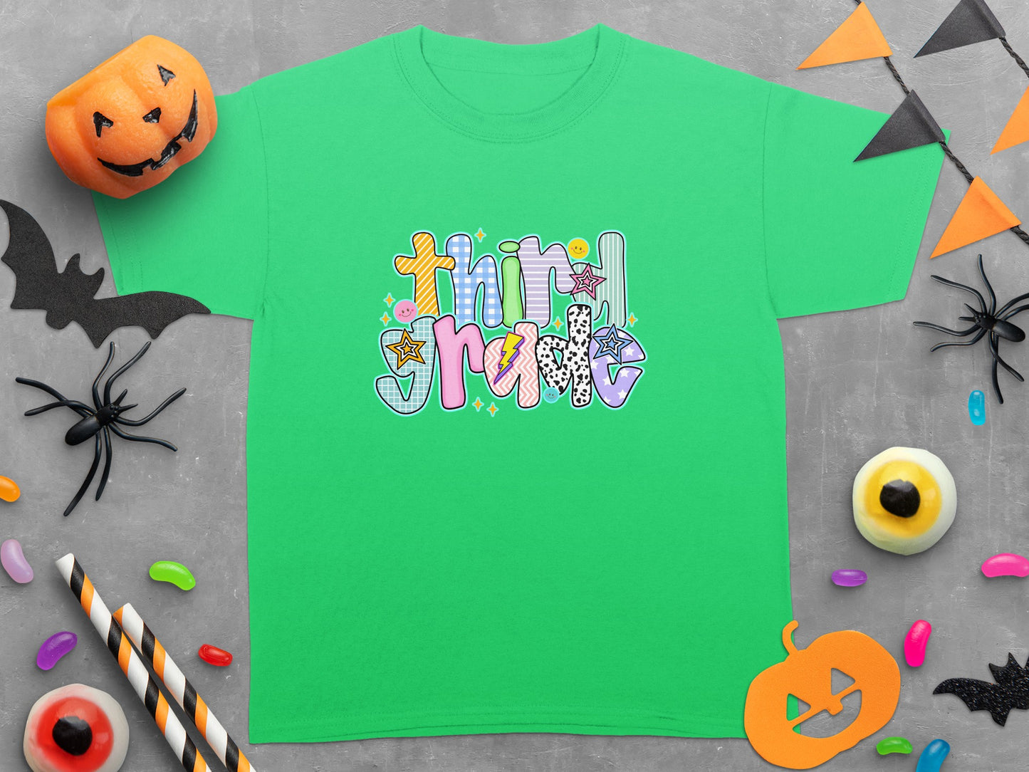 Green t-shirt with "Third Grade" Halloween graphic surrounded by decorations.