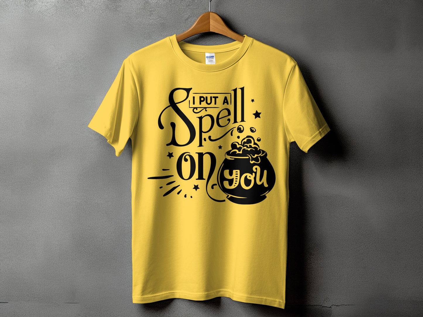 Yellow t-shirt with black text "I PUT A Spell ON YOU" and a cauldron graphic.