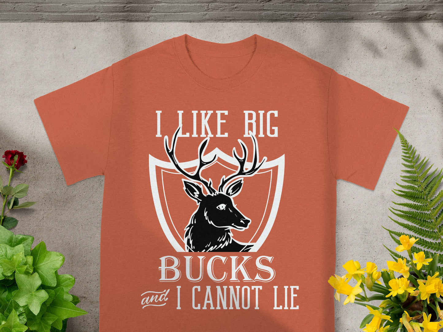 Orange t-shirt with a deer silhouette and "I LIKE BIG BUCKS and I CANNOT LIE" text.