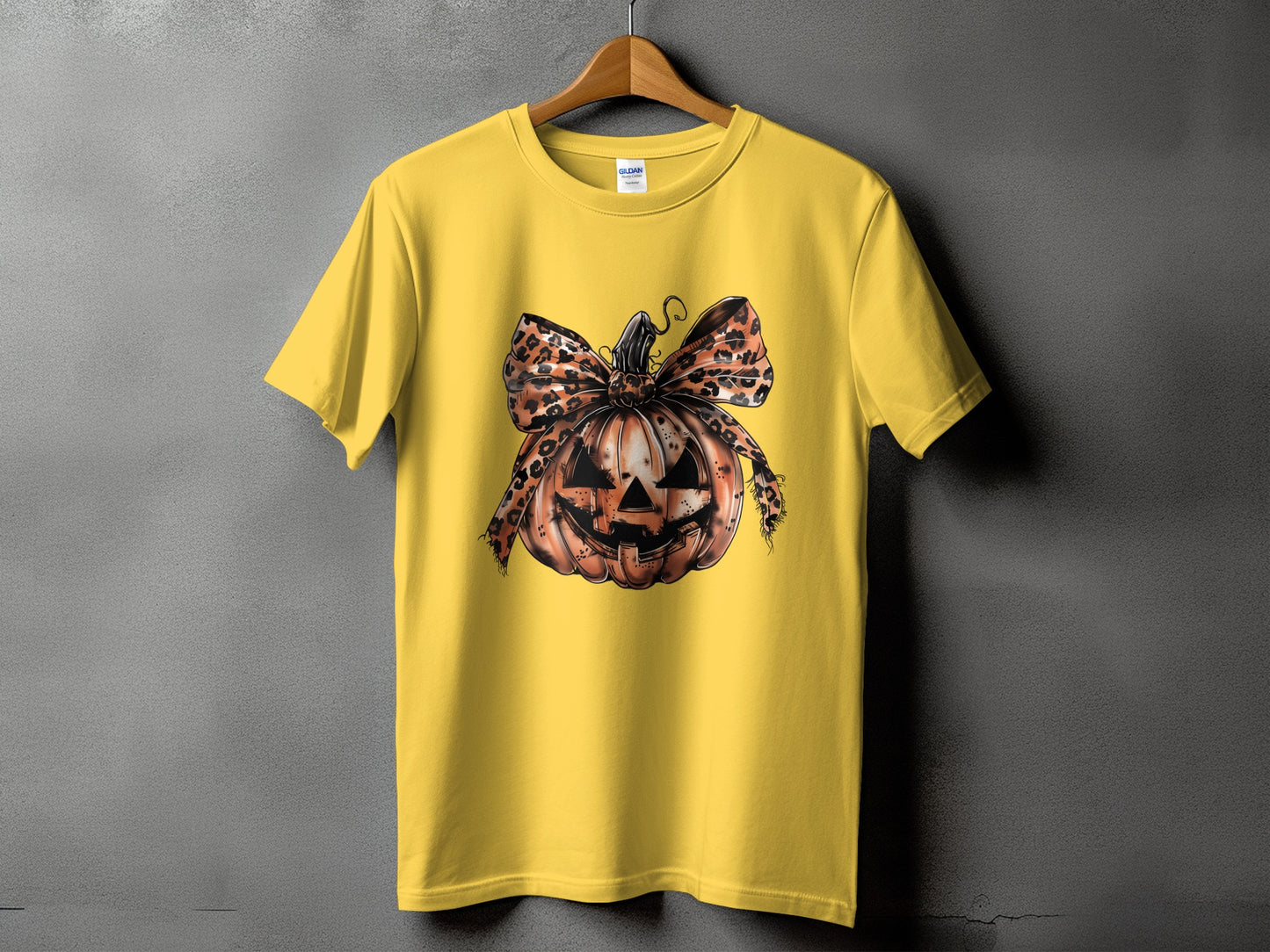 Yellow t-shirt with a distressed jack-o'-lantern and leopard print bow graphic.