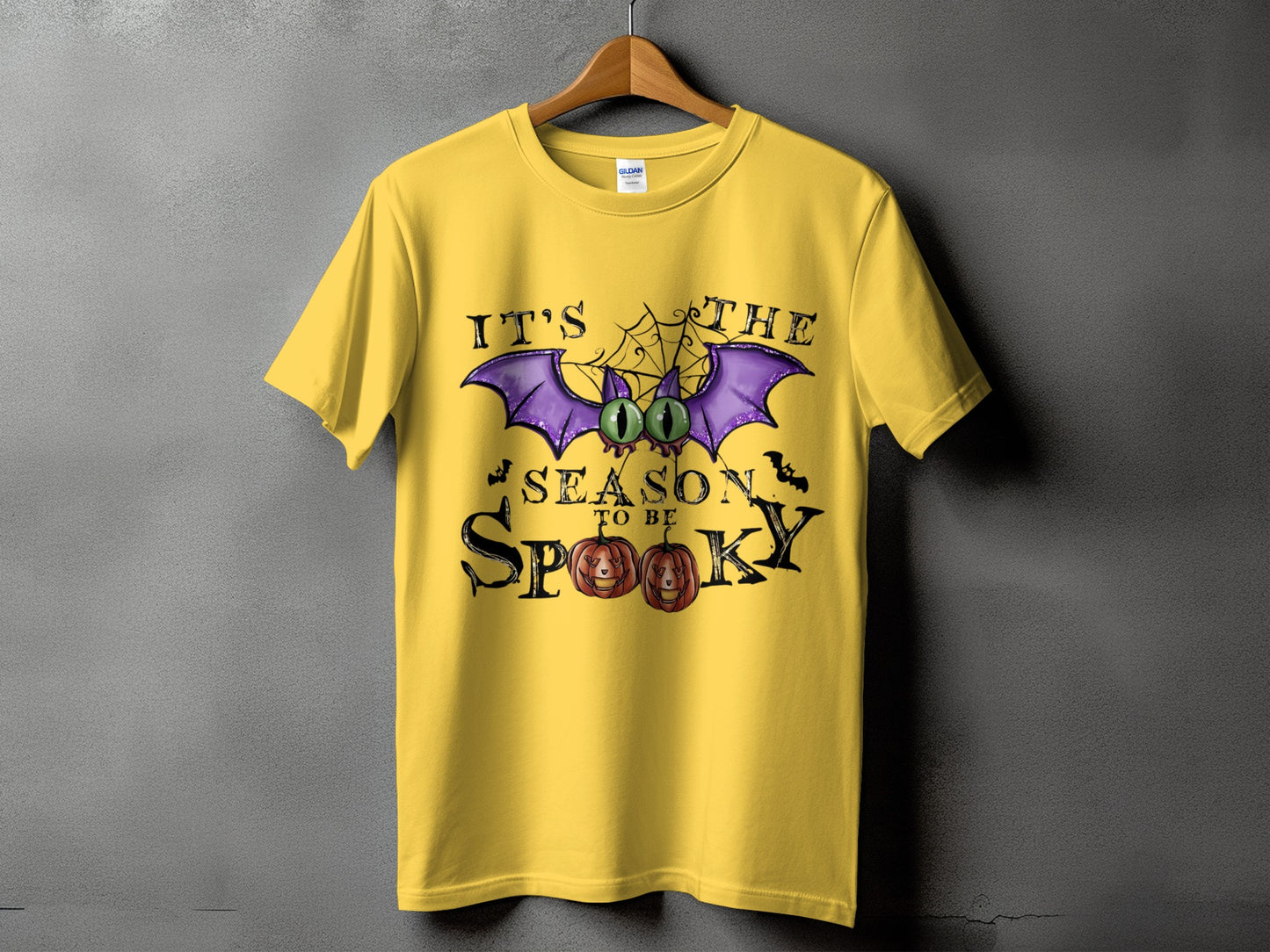 Yellow t-shirt with "It's The Season To Be Spooky" Halloween graphic.