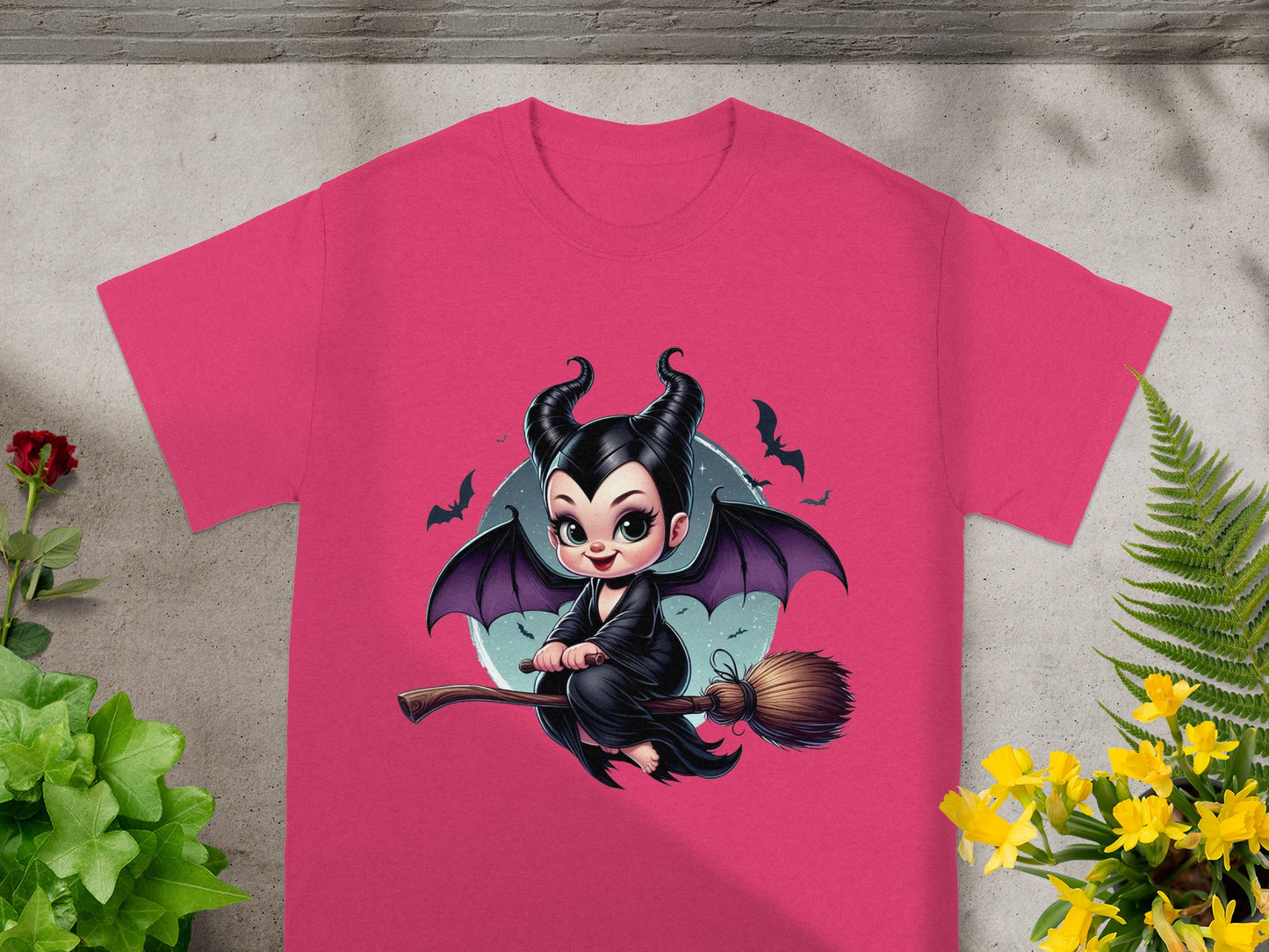 Maleficent on a broomstick with bats and yellow flowers on a pink t-shirt.