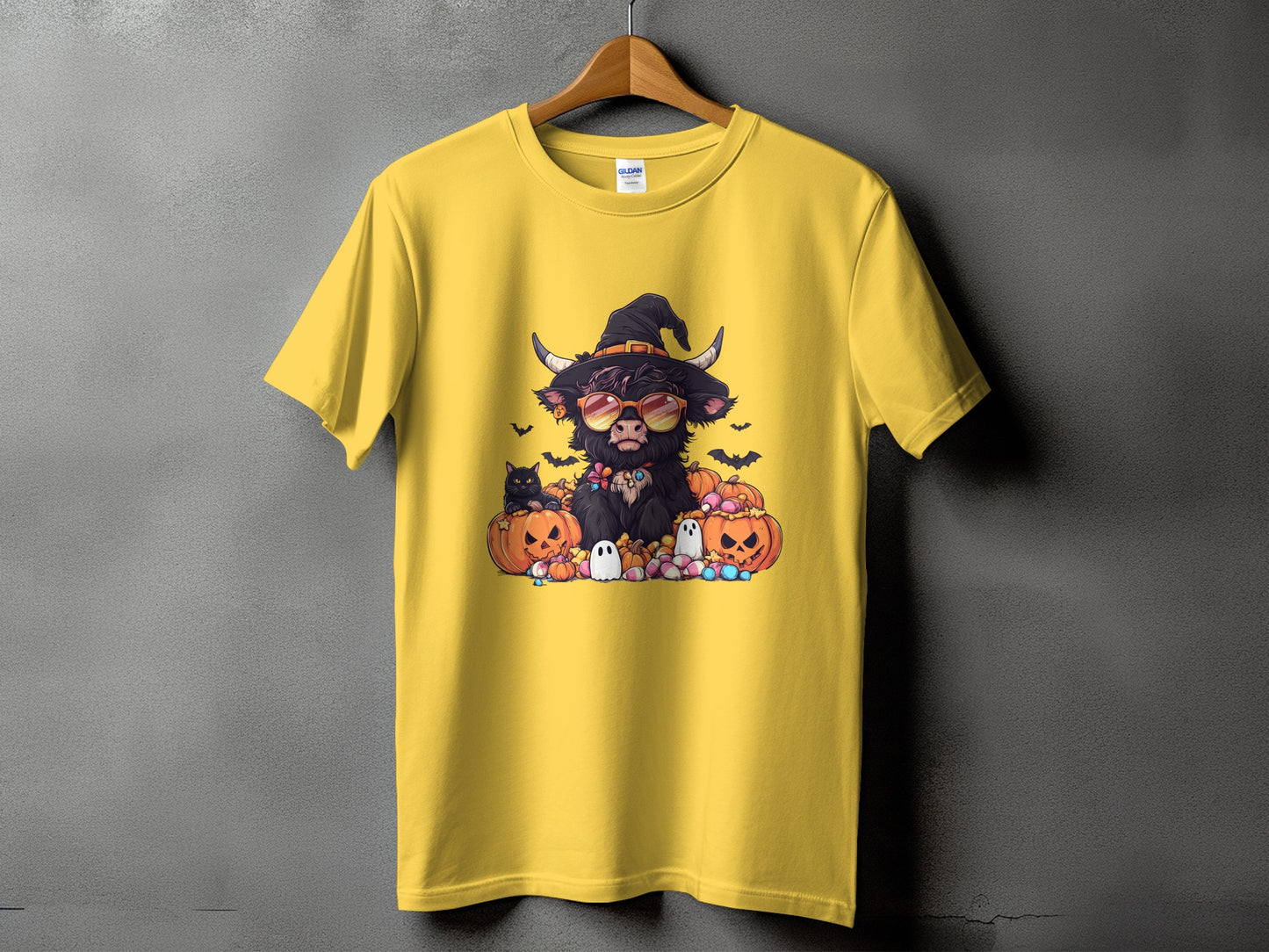 Yellow t-shirt with Halloween Highland cow, pumpkins, ghosts, and bats graphic.
