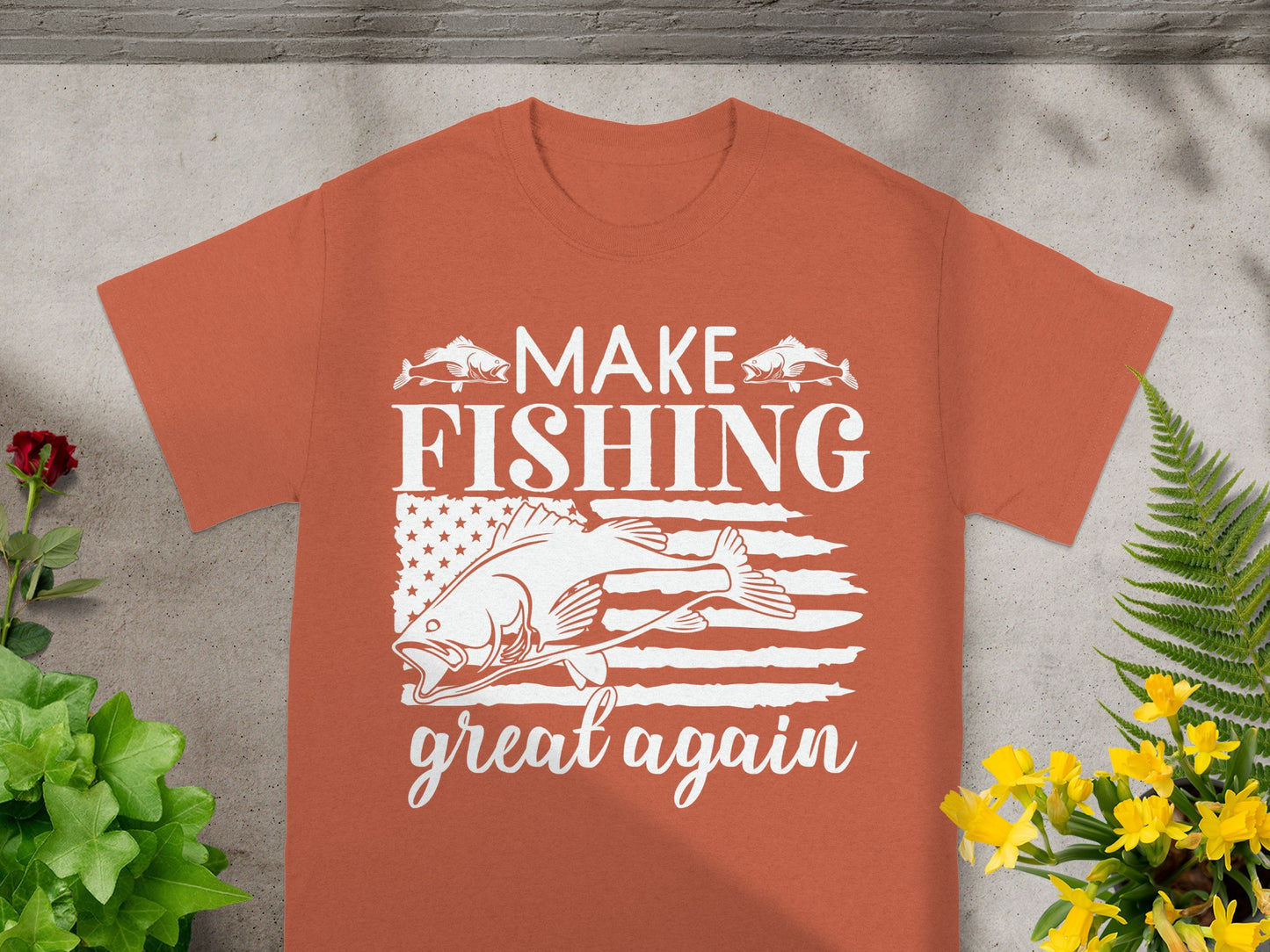 "Make Fishing Great Again" text on orange t-shirt with fish and American flag graphic.