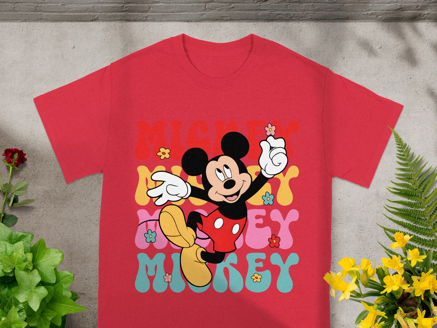 Mickey Mouse graphic t-shirt with colorful "Mickey" lettering and floral accents.