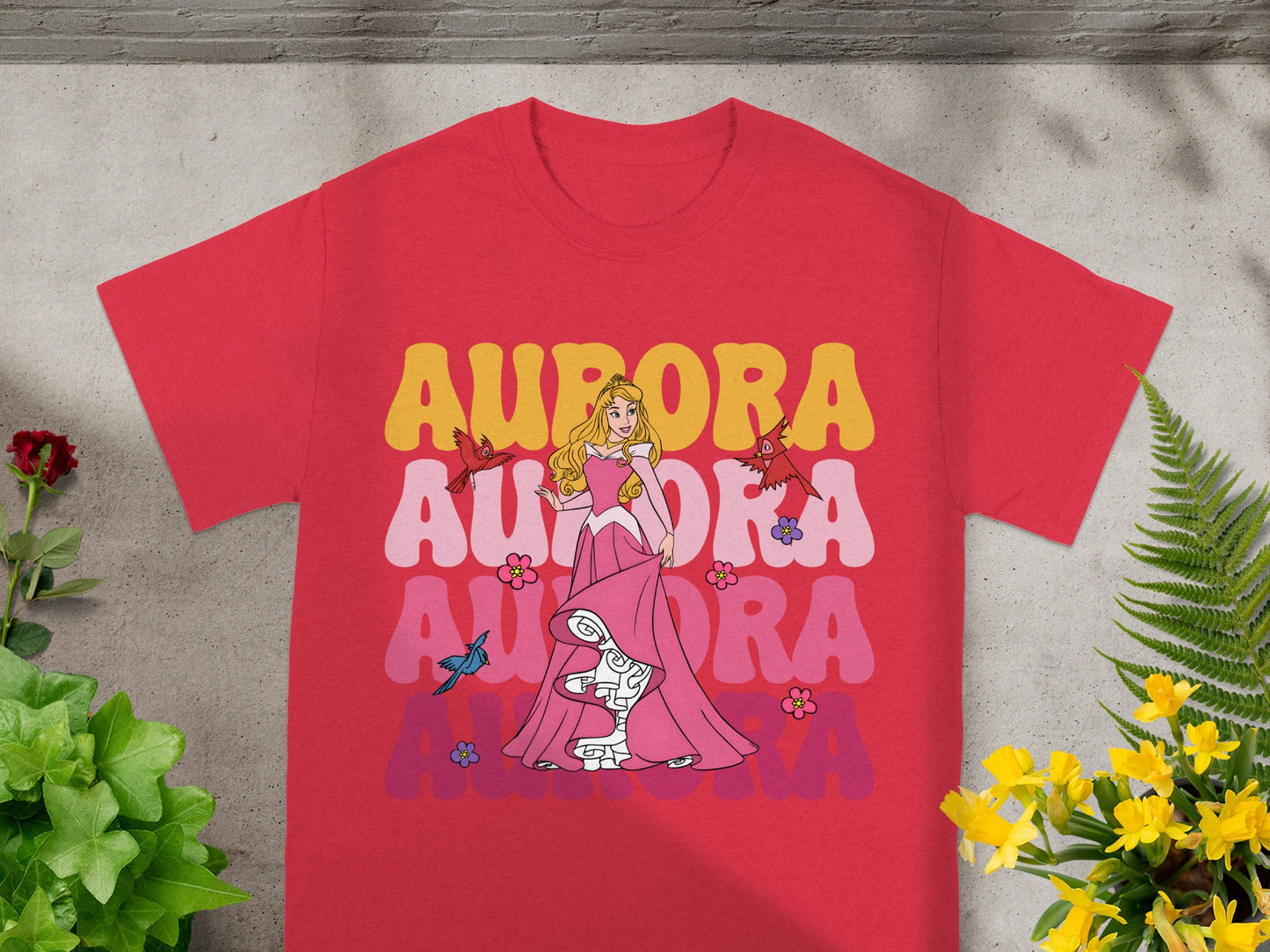Red t-shirt with Aurora, sleeping beauty, in pink, with colorful text.