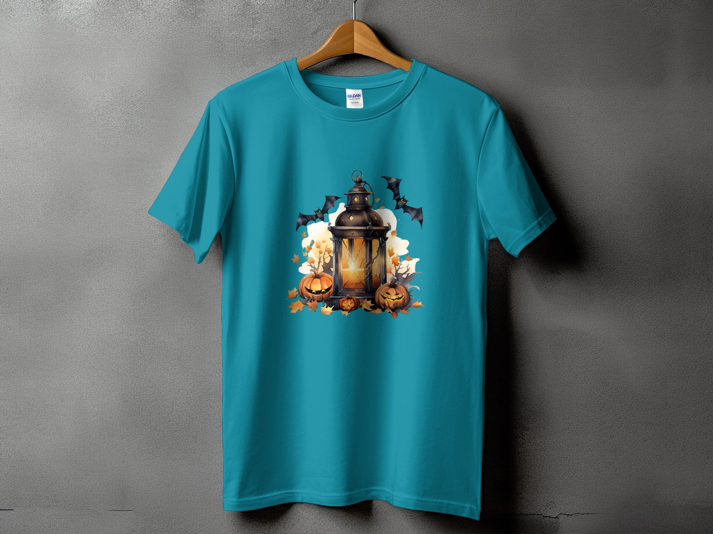 Teal t-shirt with a Halloween graphic featuring a lantern, pumpkins, and bats.