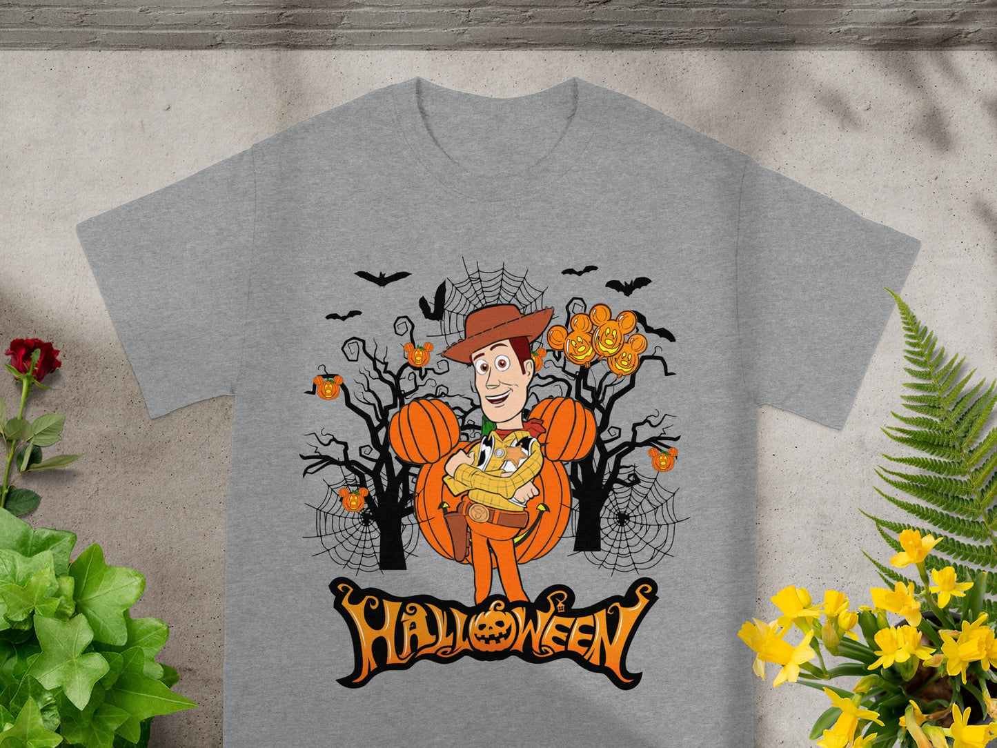 Grey t-shirt with Woody from Toy Story in a Halloween scene with pumpkins and bats.