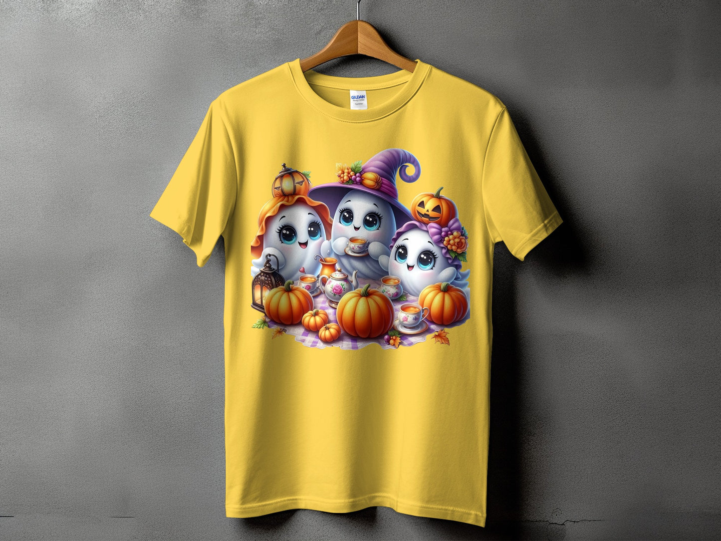 Yellow t-shirt with cute ghosts, pumpkins, and tea set graphic for Halloween.