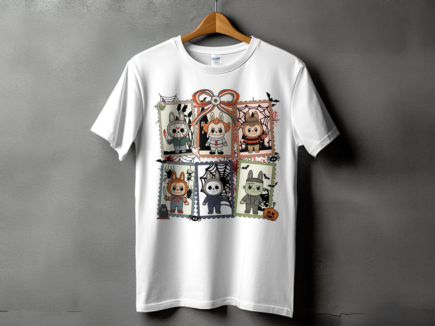 White t-shirt with a Halloween graphic featuring six cartoon monsters in postage stamp frames.
