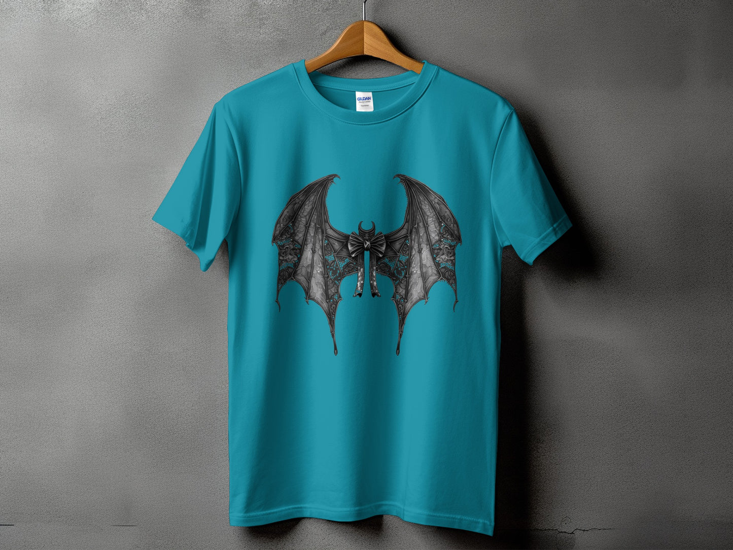 Teal t-shirt with ornate black bat wings and a bow graphic.