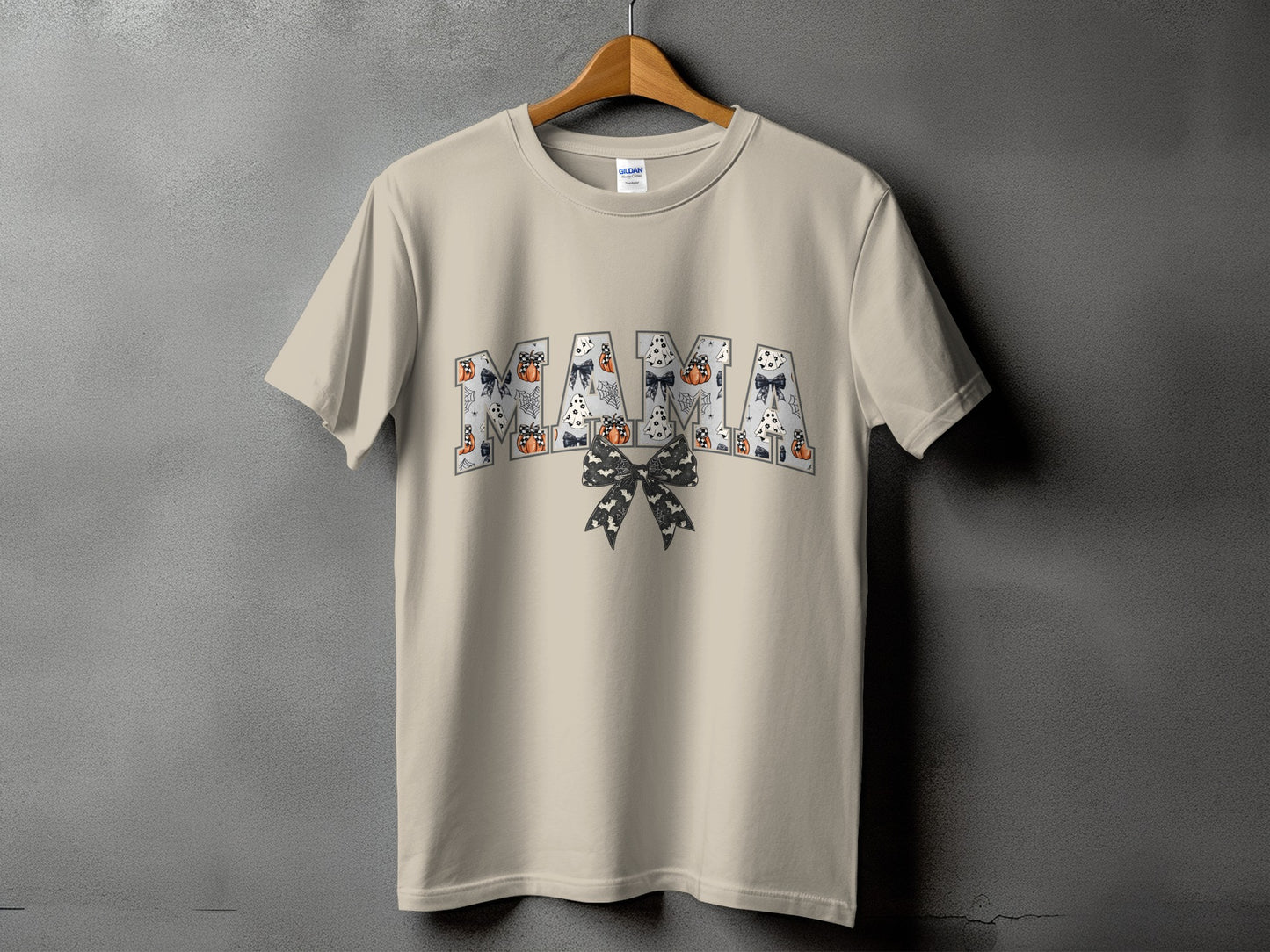 Light tan t-shirt with "MAMA" text featuring Halloween-themed graphics.