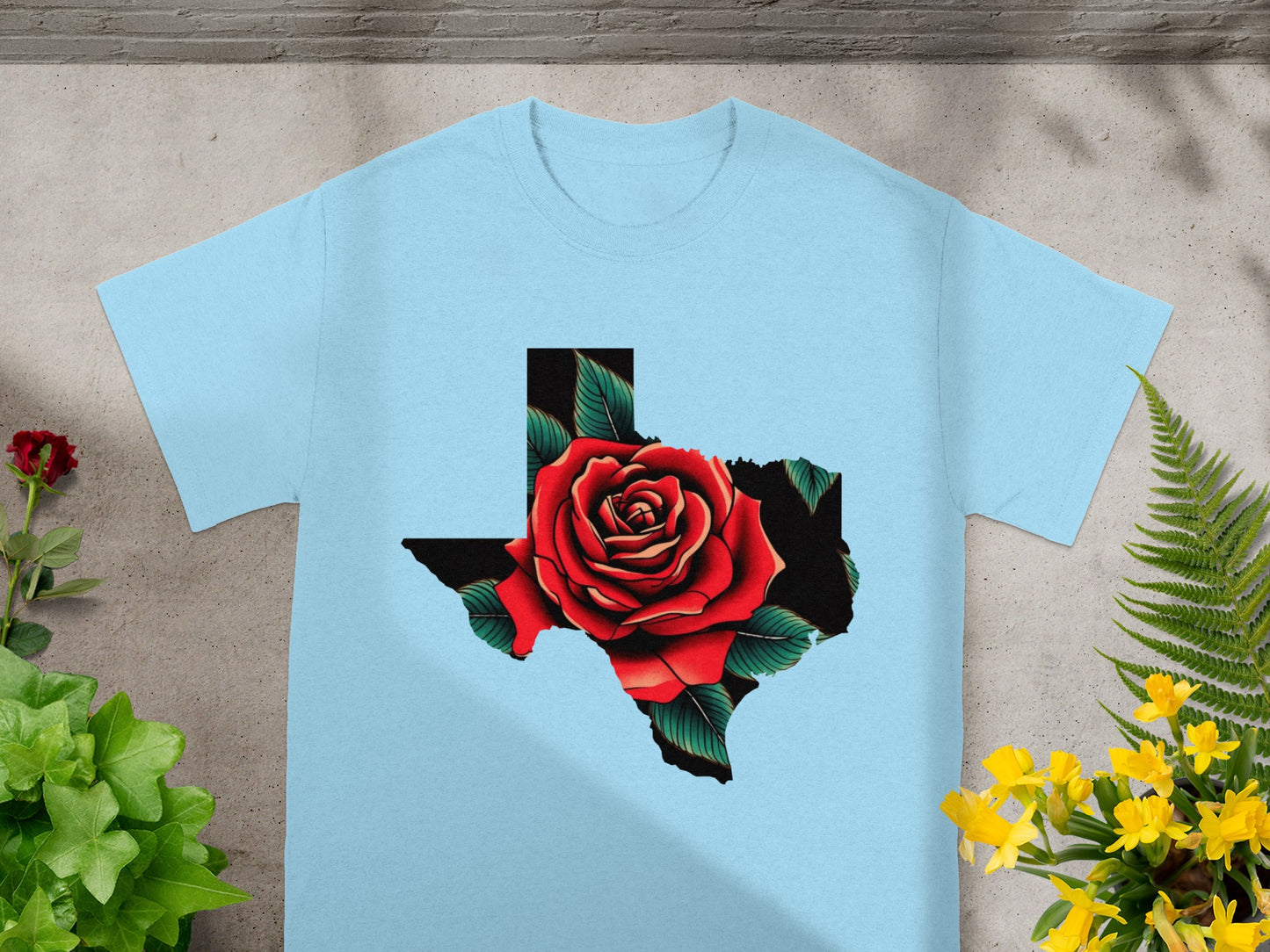 Light blue t-shirt with a black Texas shape filled with a red rose and green leaves.
