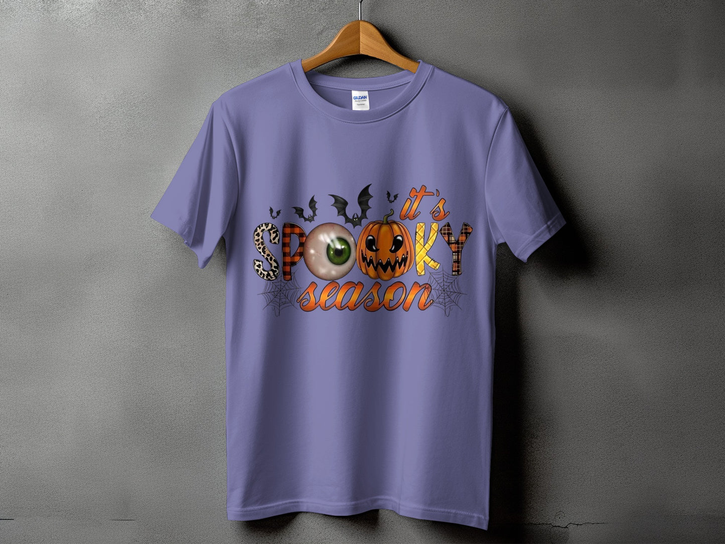Purple t-shirt with "it's spooky season" graphic featuring Halloween elements.