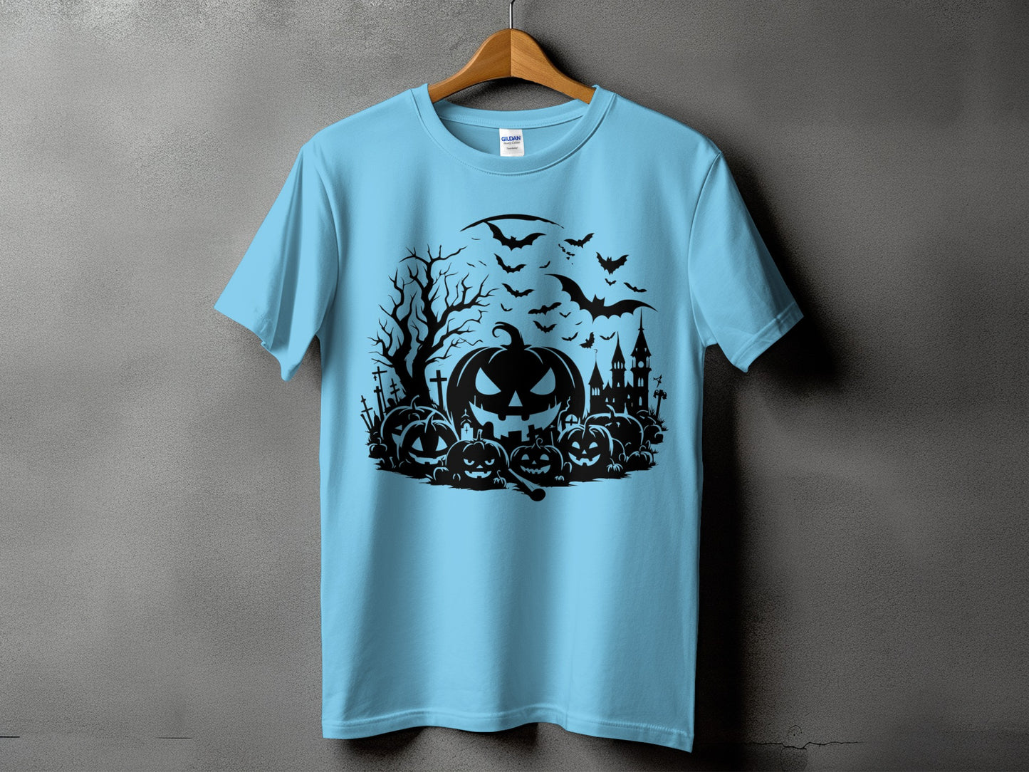 Light blue t-shirt with a black Halloween design featuring pumpkins, bats, and a castle.