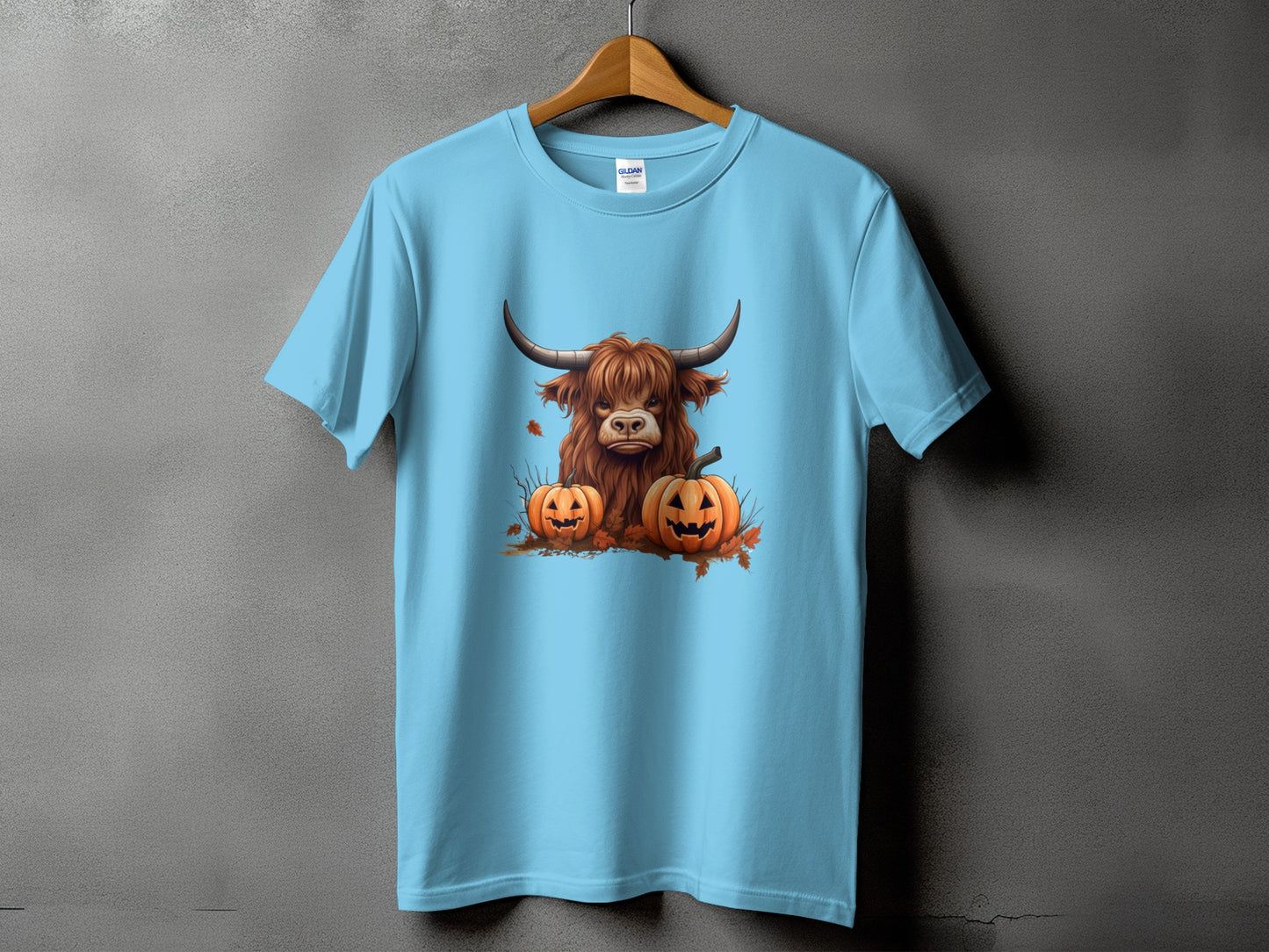 Light blue t-shirt with a Highland cow and jack-o'-lanterns Halloween graphic.