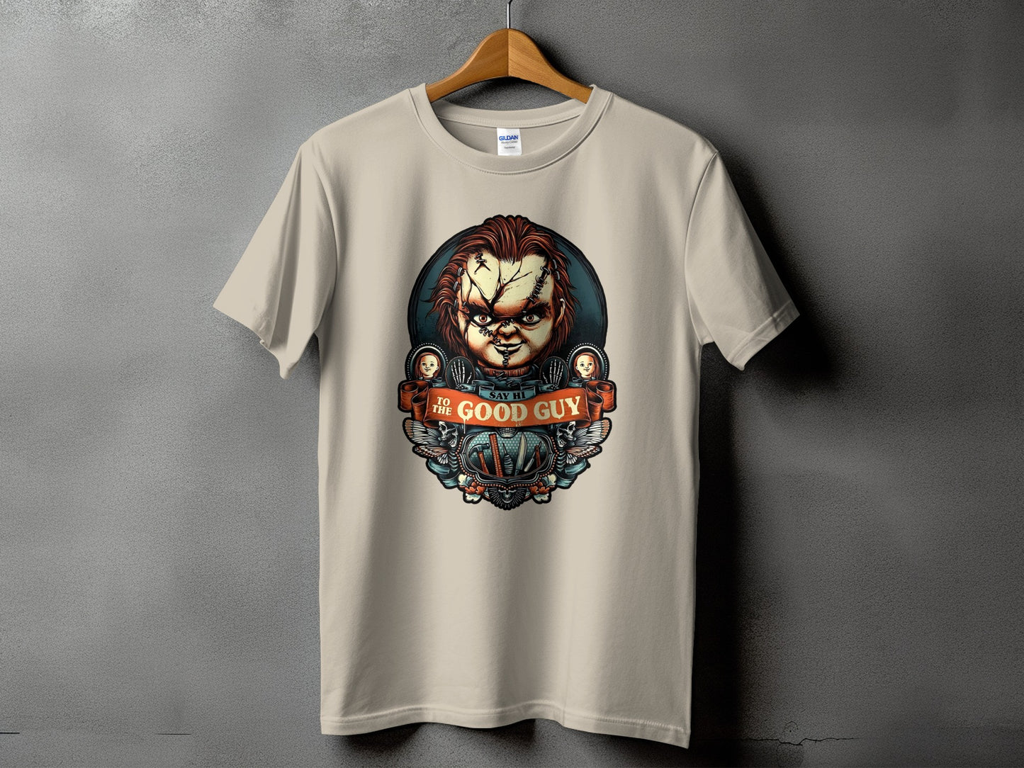 Chucky doll graphic on a tan t-shirt with "Say Hi To The Good Guy" text.