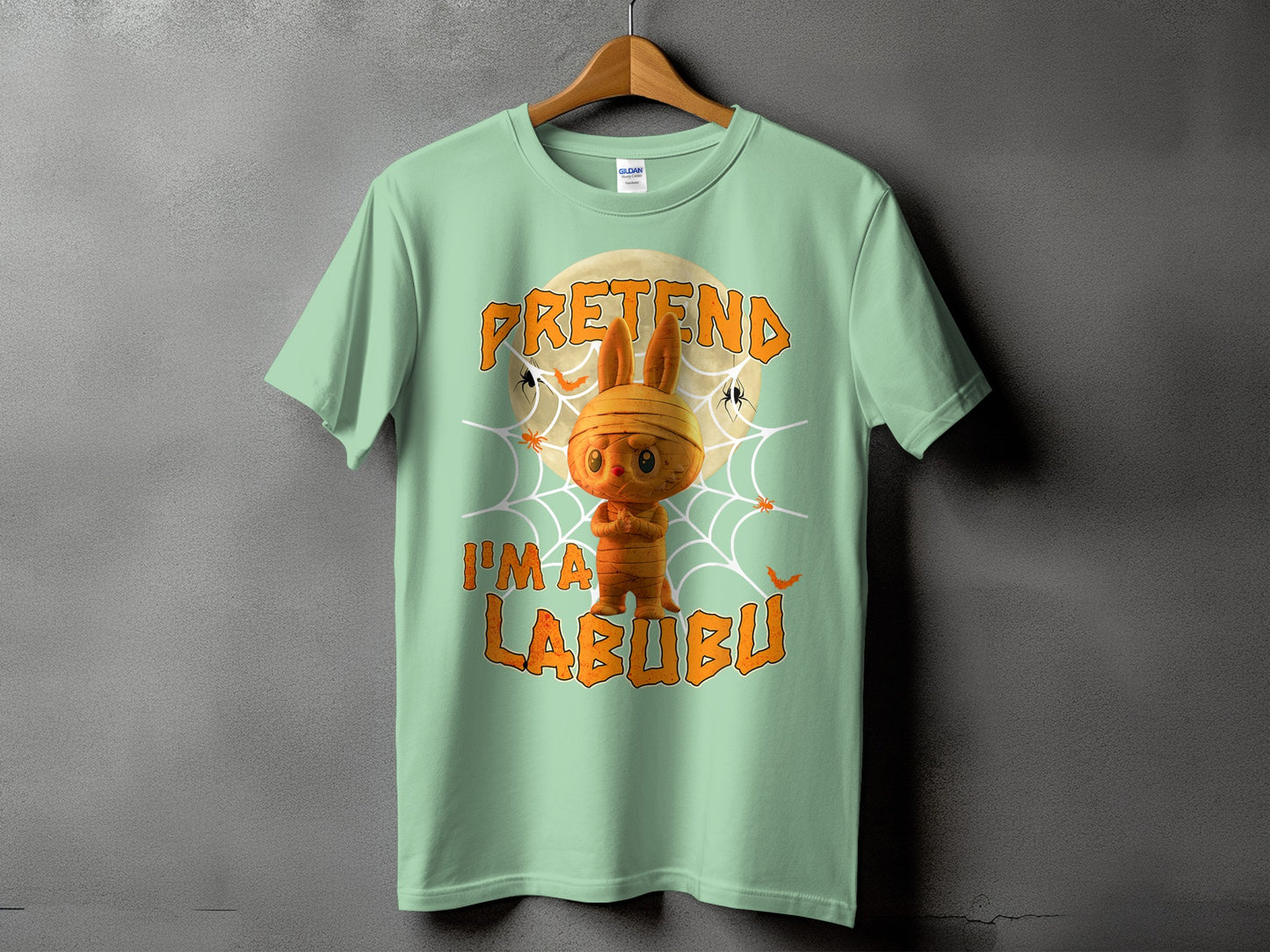 Light green t-shirt with mummy Labubu graphic and text "PRETEND I'M A LABUBU".