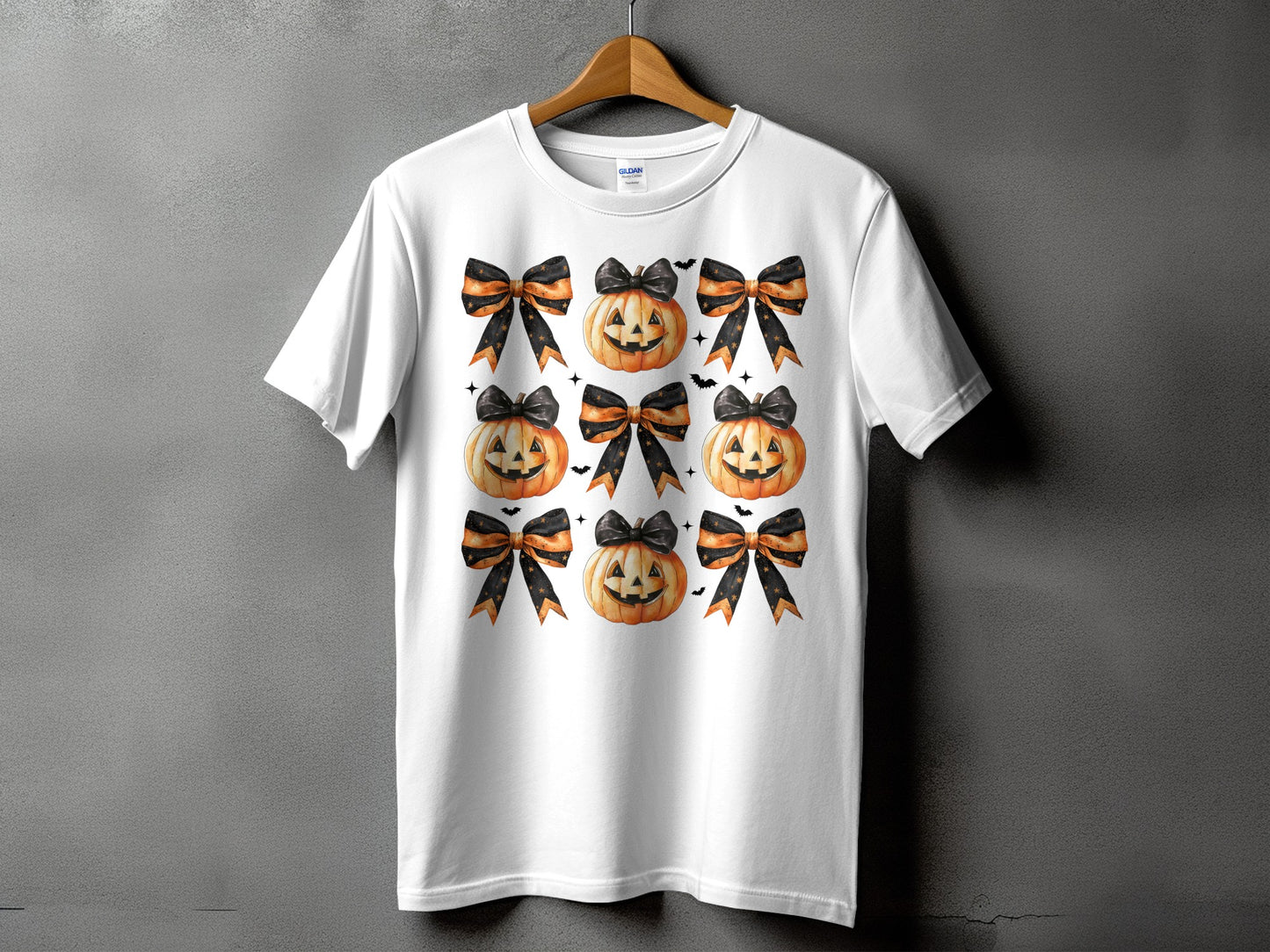 White t-shirt with a pattern of pumpkins and black and orange bows.