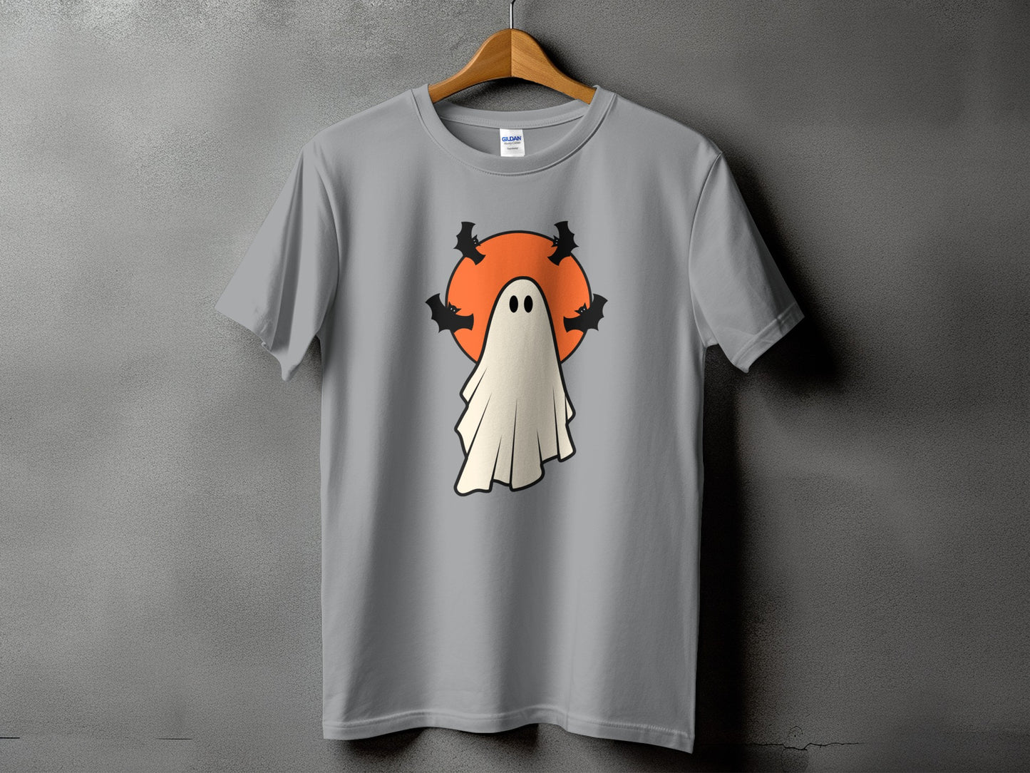 Grey t-shirt with a cartoon ghost and bats on an orange circle.