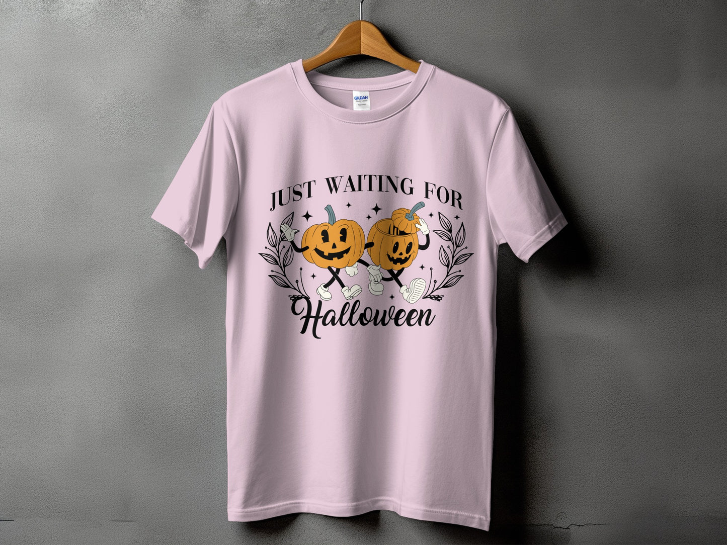 Pink t-shirt with "Just Waiting For Halloween" text and cartoon pumpkins.