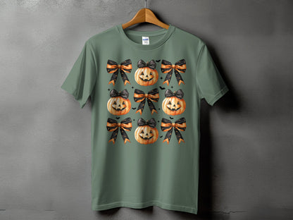 Green t-shirt with a repeating pattern of jack-o'-lanterns and orange and black bows.