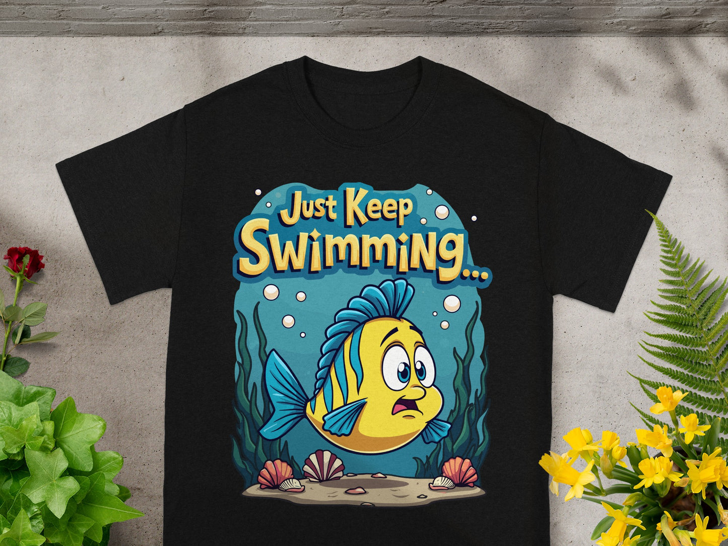Black t-shirt with cartoon yellow fish and text "Just Keep Swimming..."