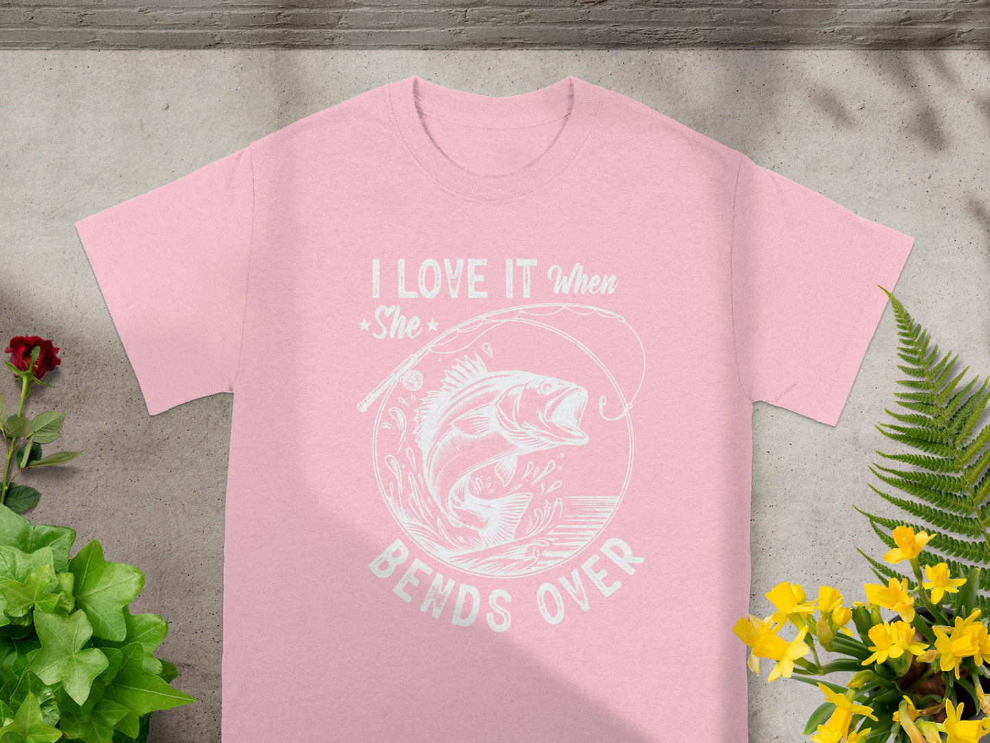 Pink t-shirt with white graphic of a jumping bass and text "I LOVE IT WHEN She BENDS OVER".