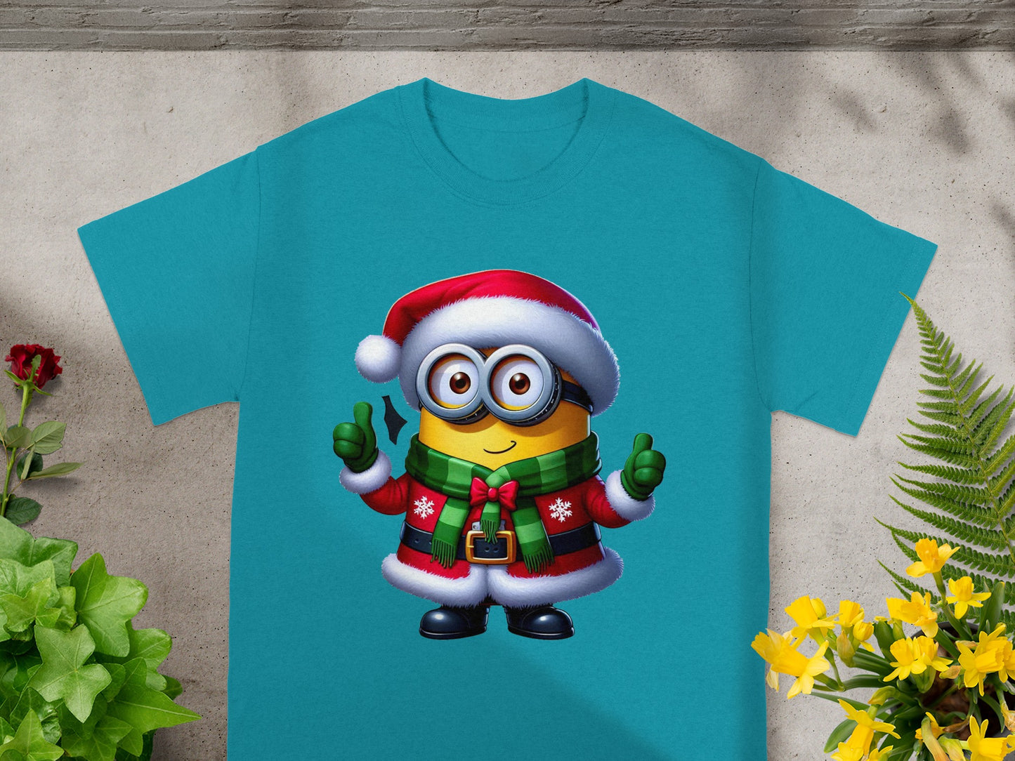 Minion character in Christmas outfit with Santa hat and scarf on a teal t-shirt.