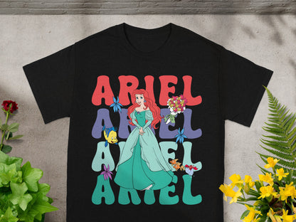 Black t-shirt with Ariel from The Little Mermaid in a green dress and text.