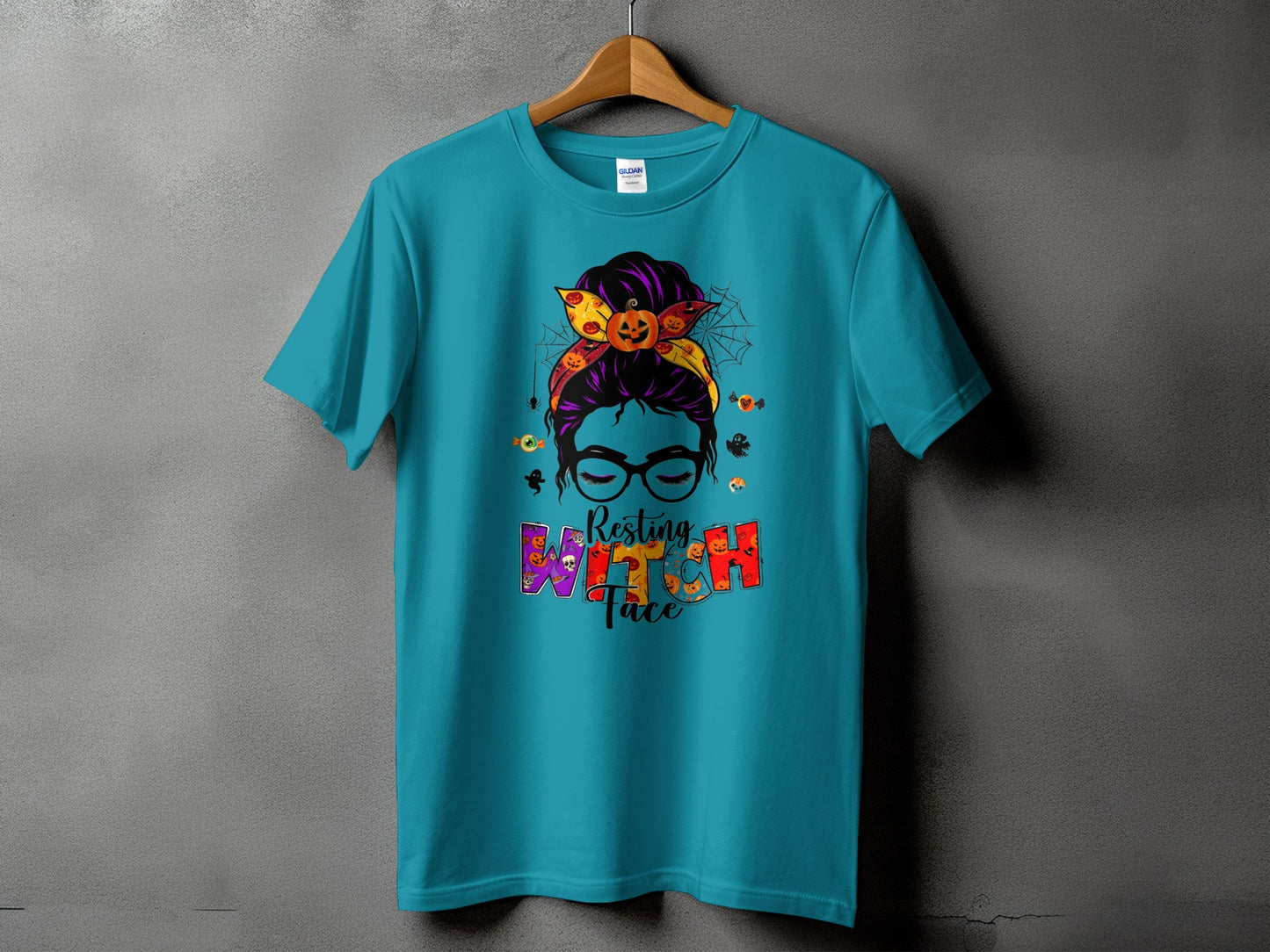 Teal t-shirt with "Resting Witch Face" Halloween graphic featuring a messy bun and pumpkins.