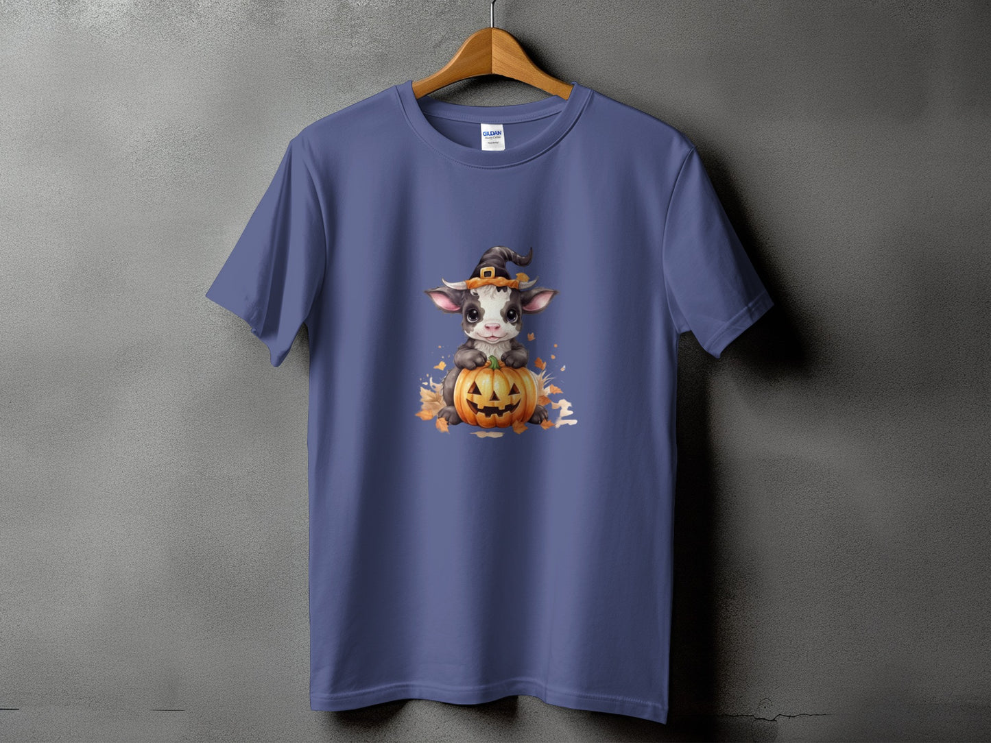 A cute cow wearing a witch hat sits on a pumpkin with autumn leaves.