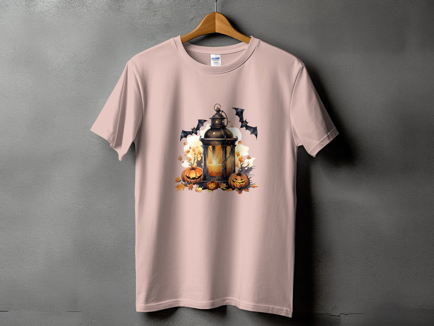 Light pink t-shirt with Halloween lantern, pumpkins, and bats graphic design.