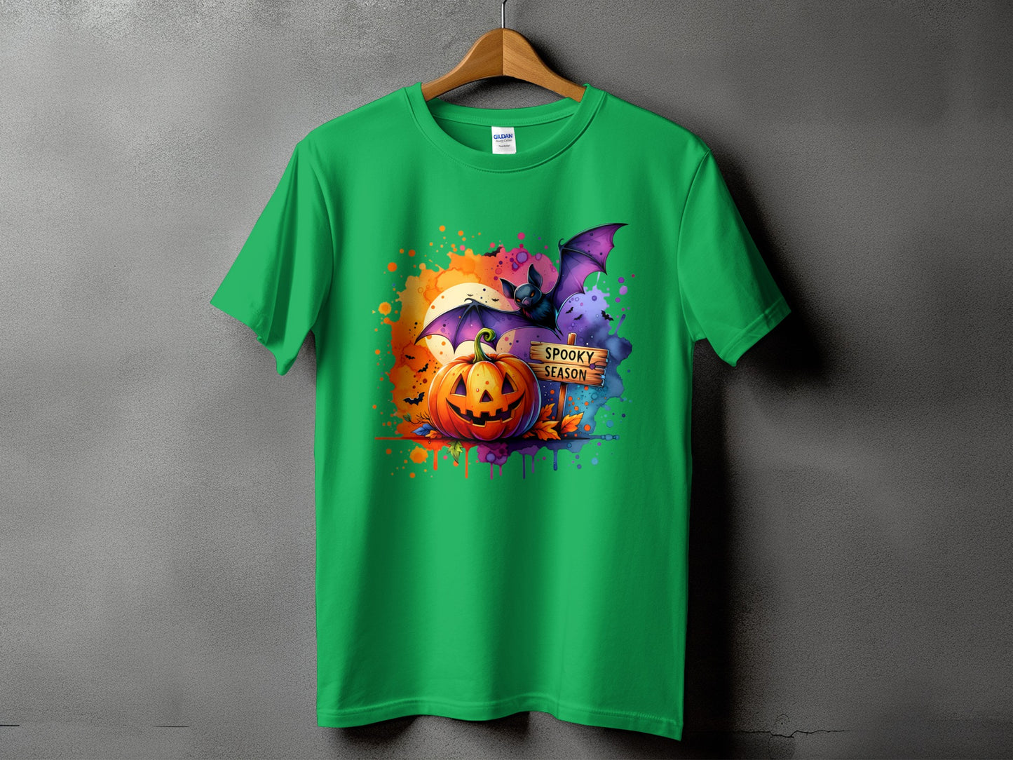 Green t-shirt with Halloween graphic featuring pumpkin, bat, and "Spooky Season" sign.