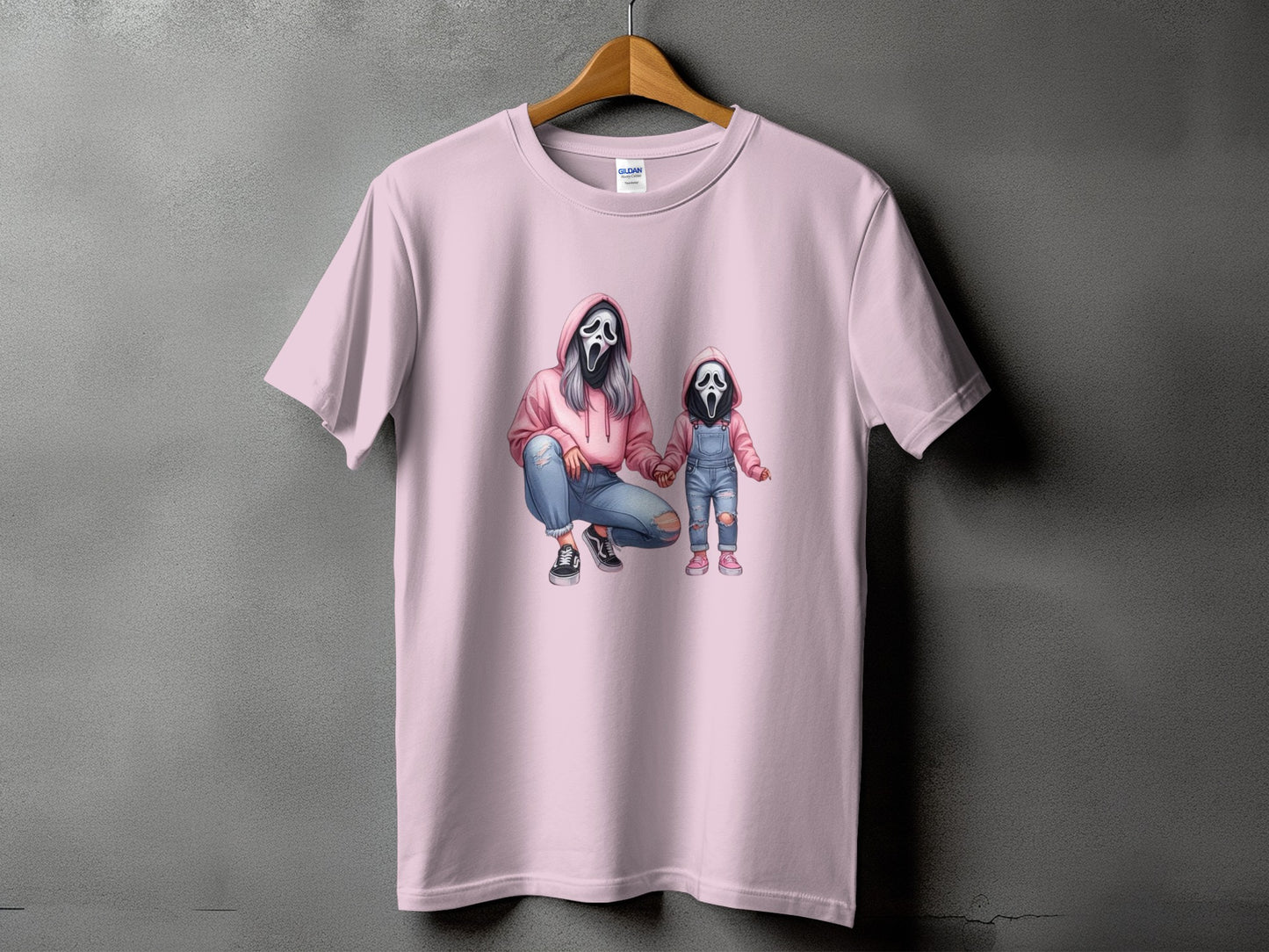 Pink t-shirt with graphic of woman and child wearing ghost masks.