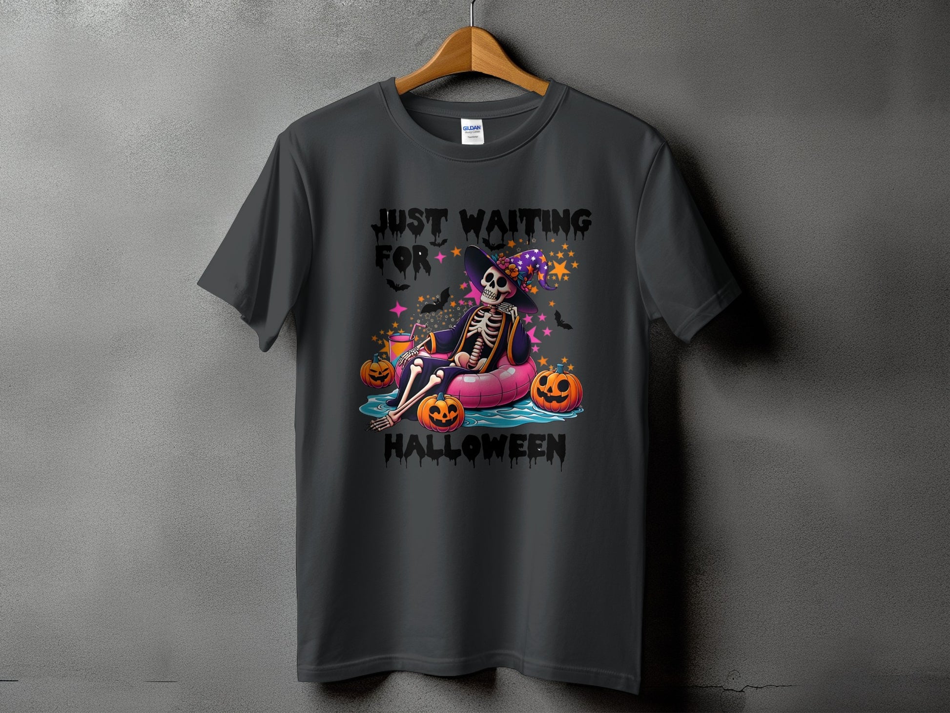 Skeleton wearing witch hat floating with pumpkins, text reads "Just Waiting For Halloween."
