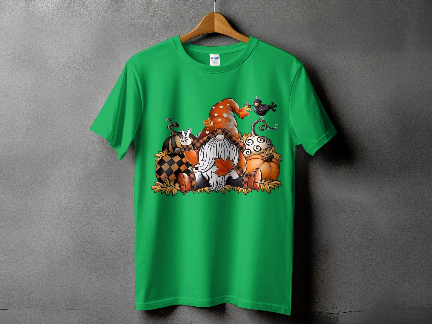 Green t-shirt with gnomes, pumpkins, and fall leaves graphic.